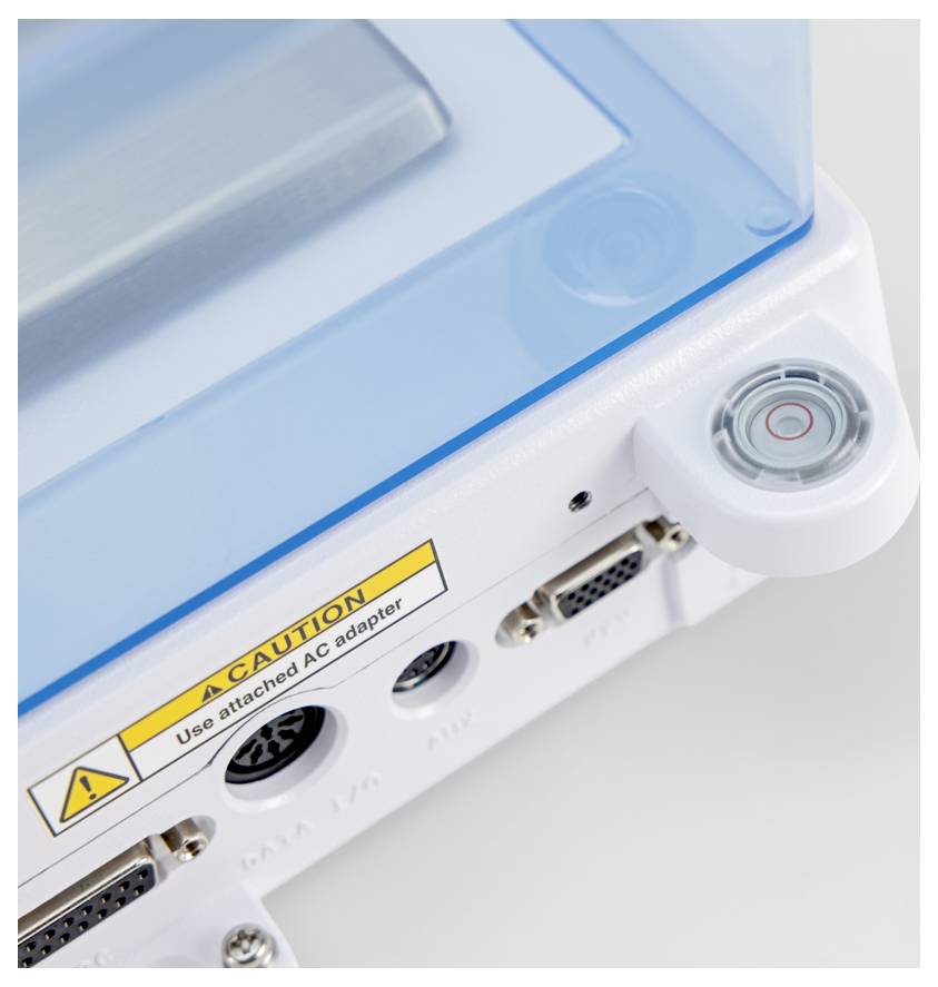 Eine Nahaufnahme eines elektronischen Geräts mit einem 'VORSICHT'-Etikett und verschiedenen Anschlüssen. Das Bild hebt Sicherheits- und Konnektivitätsfunktionen hervor.