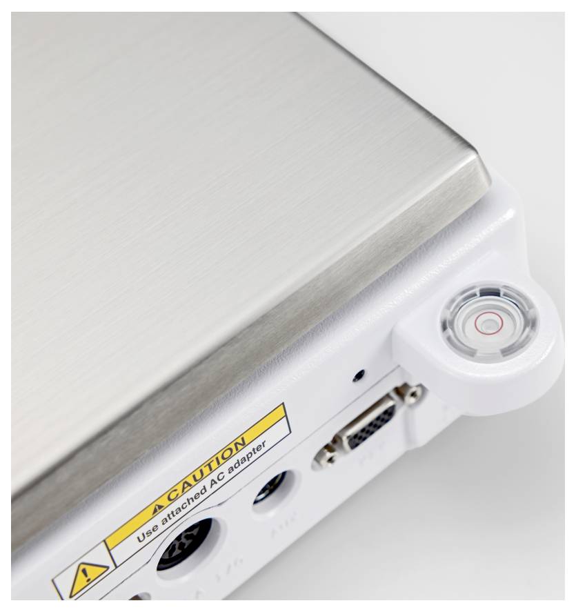 Ein Nahaufnahmebild einer metallischen Ecke eines elektronischen Geräts mit einem Stromschalter, einem USB-Anschluss und einem Vorsichtsetikett, das empfiehlt, den mitgelieferten Netzadapter zu verwenden.