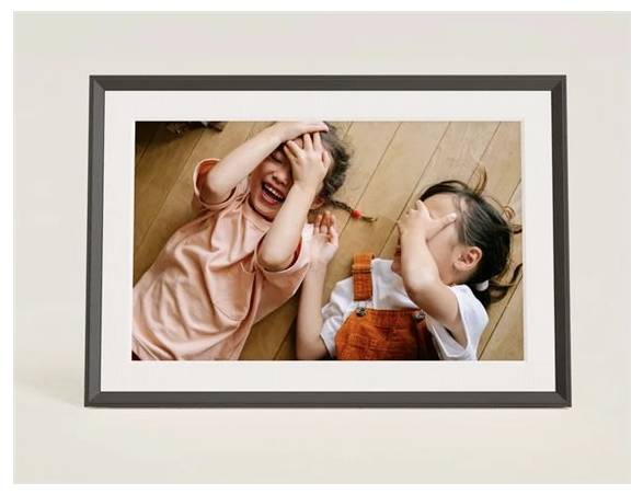 Zwei Kinder liegen auf einem Holzboden, bedecken ihre Augen und lachen, wobei sie eine verspielte und freudige Szene schaffen.