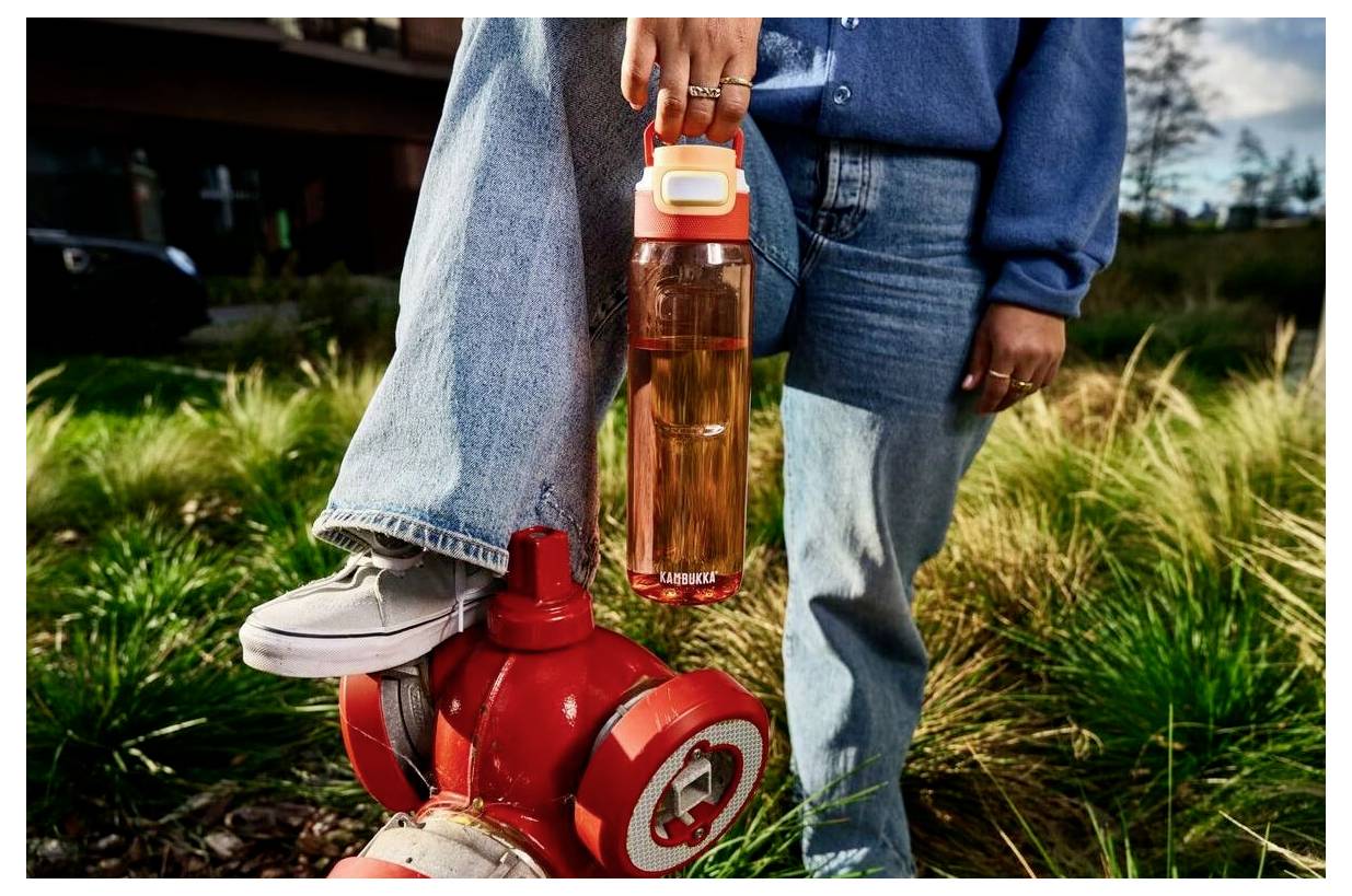 Eine Person hält eine große Wasserflasche mit der Aufschrift „ZAMZAR
