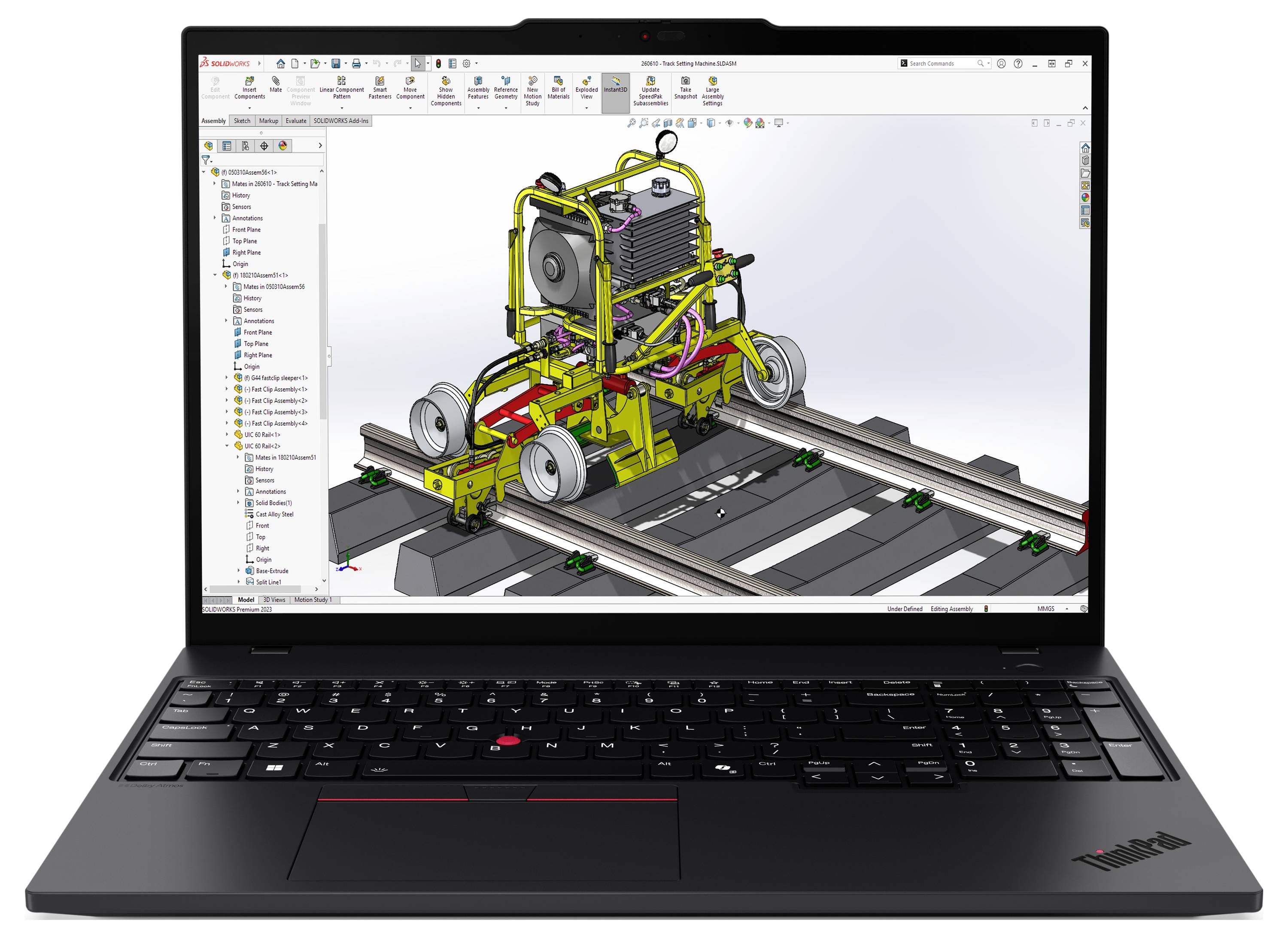 Ein Laptop, auf dem ein 3D-CAD-Modell einer schienengebundenen Maschine mit Rädern und einem Motor angezeigt wird, das in einer Ingenieursoftware-Oberfläche integriert ist.