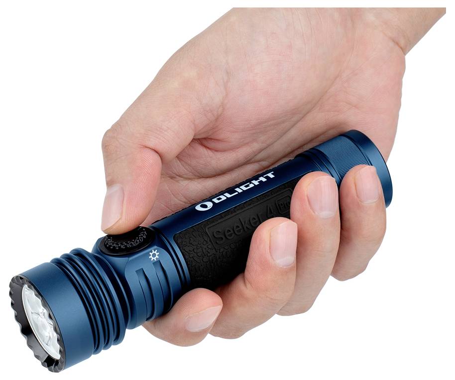 Eine Hand hält eine blaue Taschenlampe mit der Aufschrift „OLIGHT" und „Seeker 4" darauf, wobei der Daumen einen schwarzen Knopf in der Nähe der Front drückt.