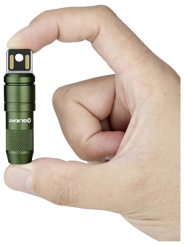 Eine Hand, die eine kleine grüne Taschenlampe mit USB-Anschluss der Marke „OLIGHT
