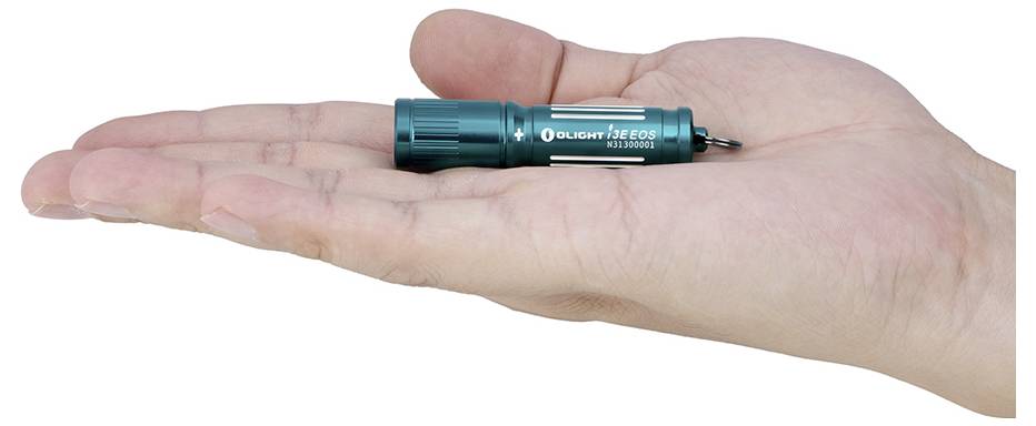 Eine Hand hält eine kleine, türkisfarbene Taschenlampe mit der Aufschrift 