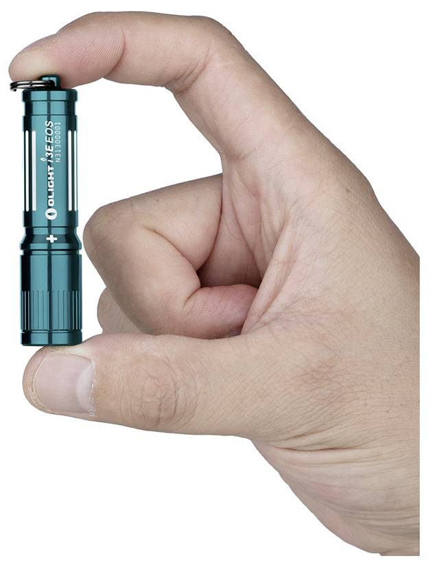 Eine Hand hält eine kleine, türkisfarbene Taschenlampe und zeigt ihre kompakte Größe. Die Taschenlampe wird vertikal dargestellt und ein sichtbares Markenlogo ist erkennbar.