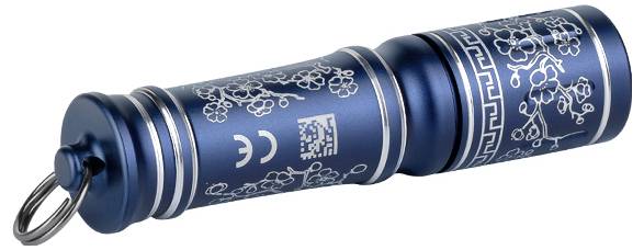 Eine kleine blaue Taschenlampe mit silbernen floralen Designs und einem Schlüsselring.