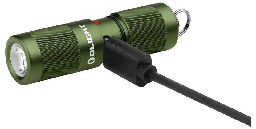 Eine kleine grüne Taschenlampe mit angeschlossenem USB-Ladekabel, Markenname „OLIGHT" sichtbar, rote Anzeigelampe oben und Schlüsselring angebracht.