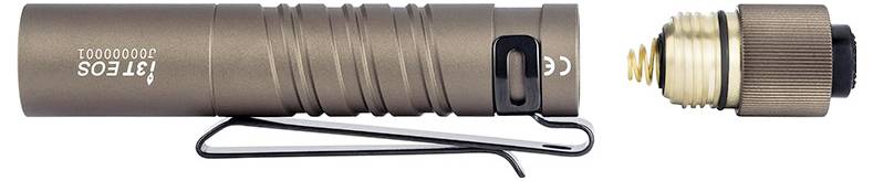 Eine kleine, zylindrische Taschenlampe in Braun mit einem Hosenclip. Die Endkappe der Taschenlampe ist abgeschraubt und neben ihr positioniert, wodurch die Batterie sichtbar wird.