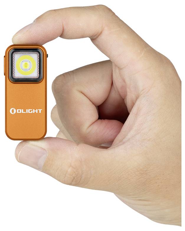 Eine Hand, die eine kleine, rechteckige, orangefarbene Taschenlampe mit der Aufschrift „Olight" hält und ihre kompakte Größe im Verhältnis zu den Fingern zeigt.
