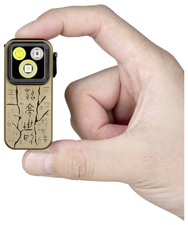 Eine Hand hält eine kompakte Taschenlampe mit steinähnlicher Textur und hieroglyphisch gestalteten Markierungen.