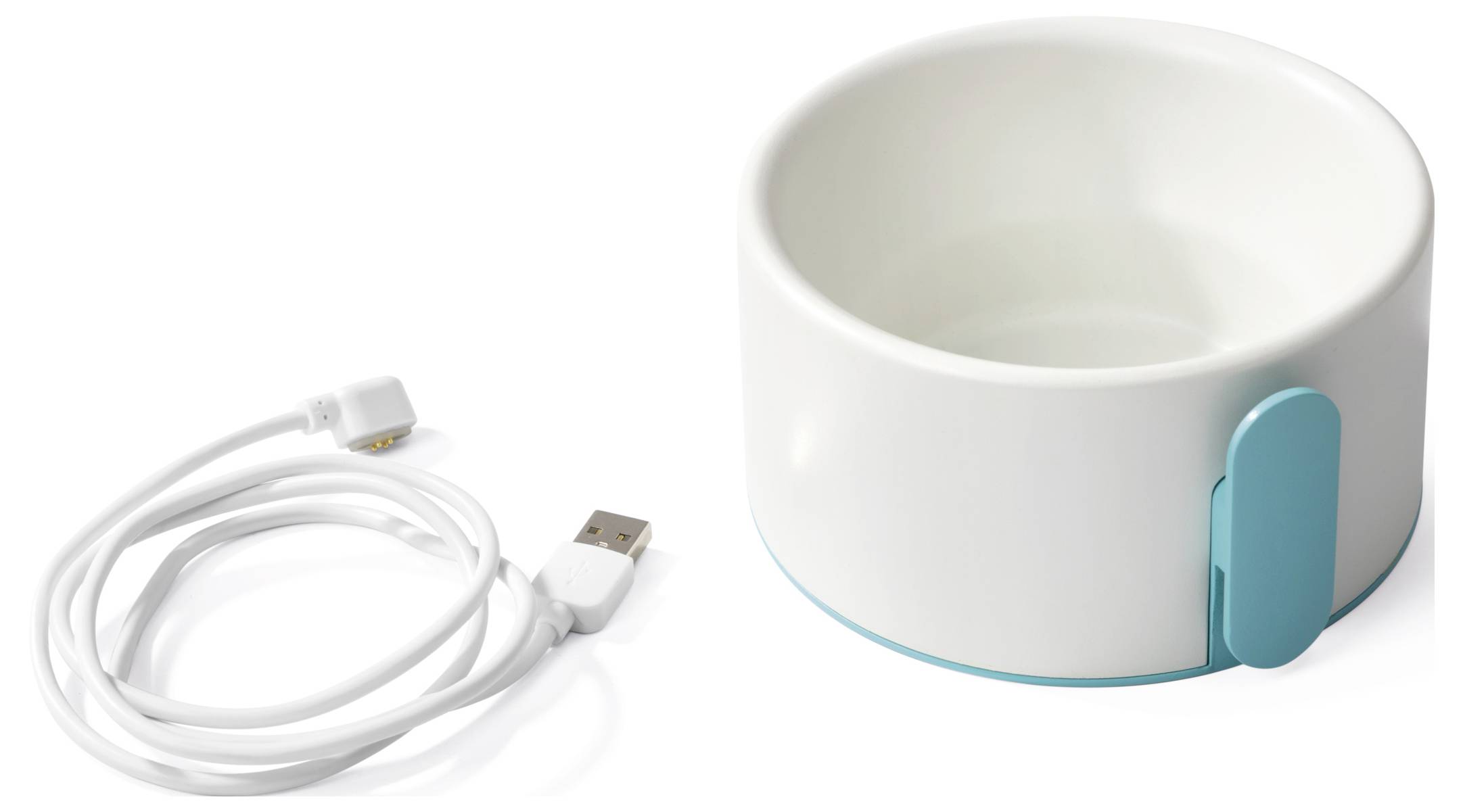 Eine weiße Keramiknapf für Haustiere mit blauem Sockel, neben einem USB-Ladekabel.