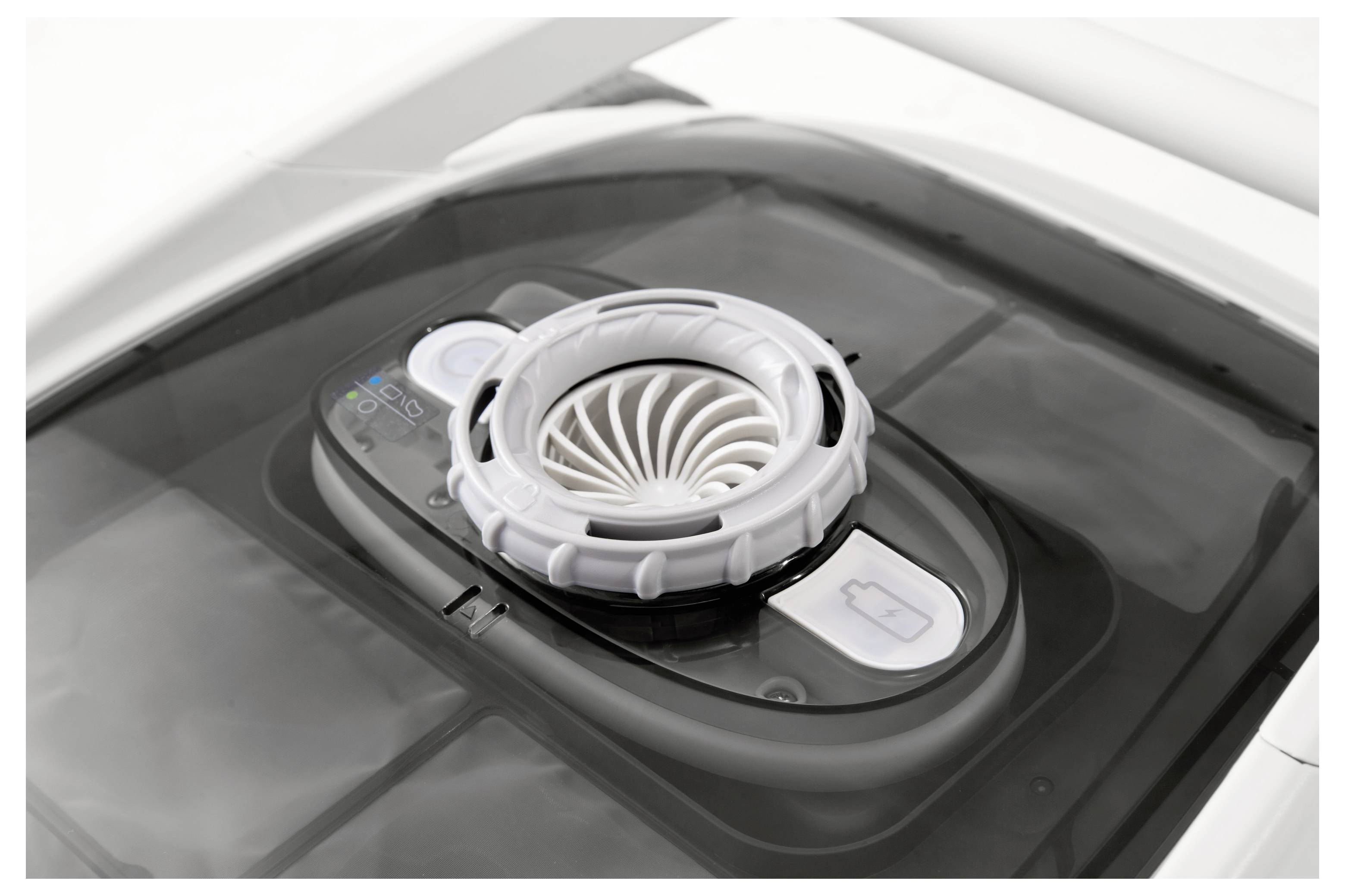 Ein schwarz-weißer Luftumwälzer mit kreisförmiger Lüftungsöffnung und Bedienfeld. Er scheint sich auf dem Dach eines Fahrzeugs zu befinden.