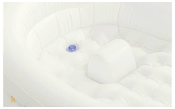 Eine aufblasbare weiße Wanne mit strukturiertem Boden und einem blauen runden Stopfen am Boden.