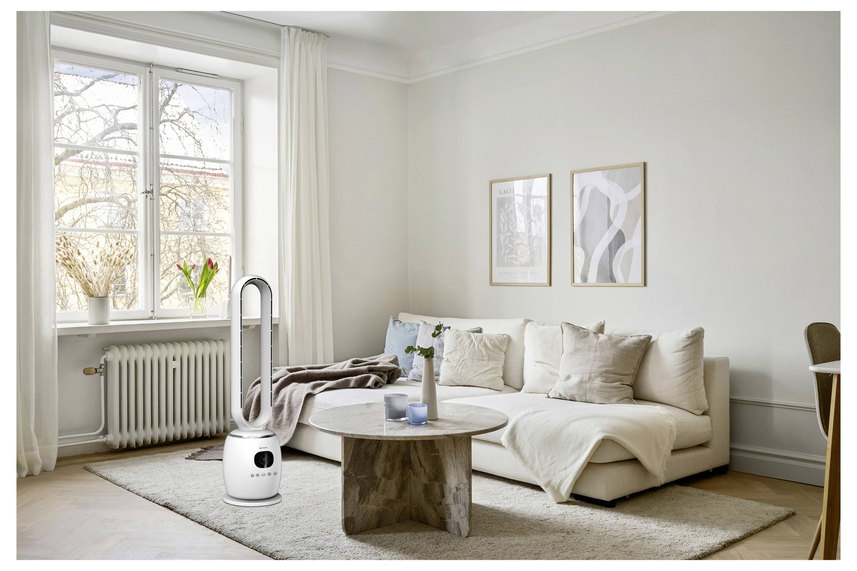 Ein modernes Wohnzimmer mit weißem Sofa, rundem Holzcouchtisch und großem Fenster. Ein hoher, eleganter Luftreiniger steht neben dem Sofa.