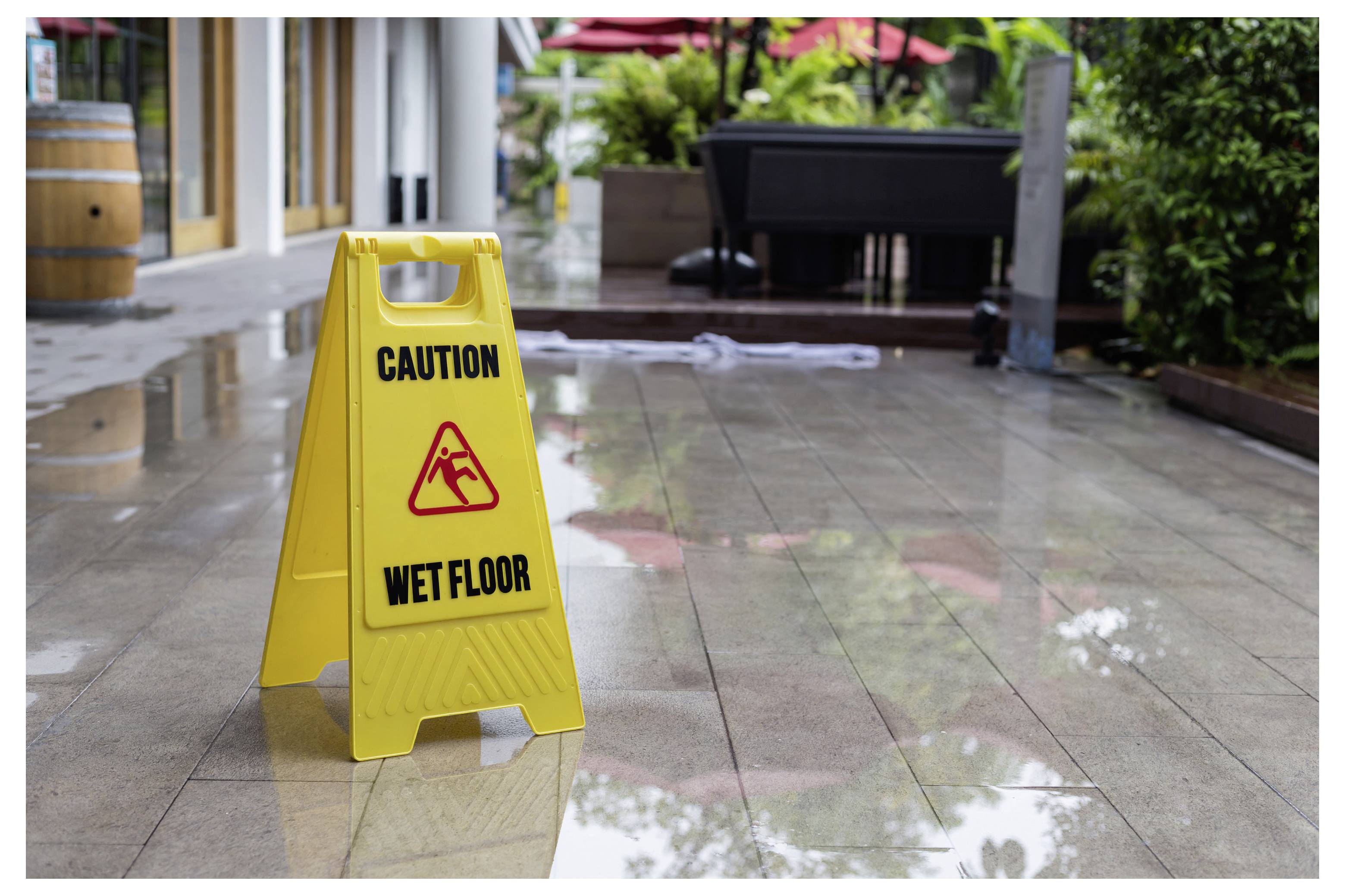 Gelbes Warnschild mit der Aufschrift „CAUTION WET FLOOR