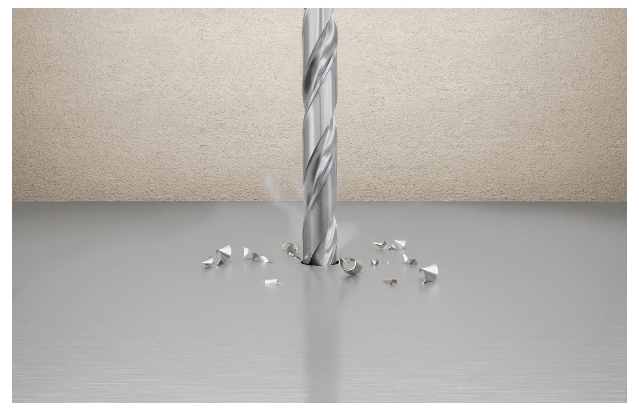 Ein Bohrmeißel schneidet in eine flache graue Oberfläche ein, umgeben von kleinen Metallspänen, vor einem beigen strukturierten Wandhintergrund.