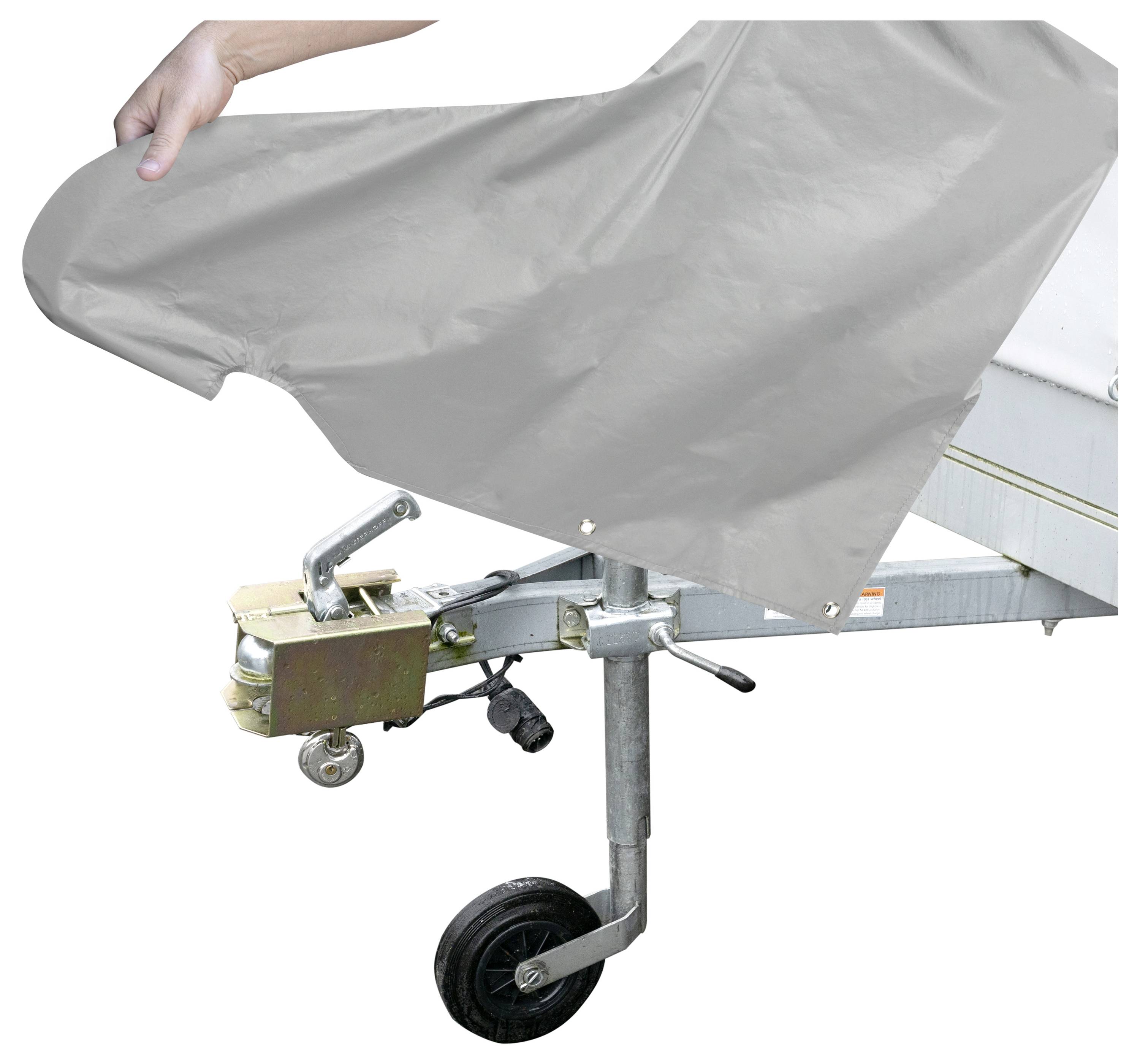 Eine Hand legt eine graue Abdeckung über eine Anhängerkupplung und betont damit den Schutz und die Wartung der Ausrüstung des Anhängers.