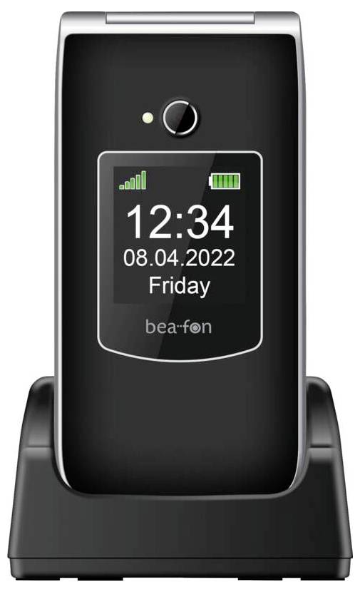 „Bea-fon" Klapphandy auf einer Ladestation, das auf dem Bildschirm „12:34, 08.04.2022, Freitag" mit Signal- und Batteriesymbolen anzeigt.