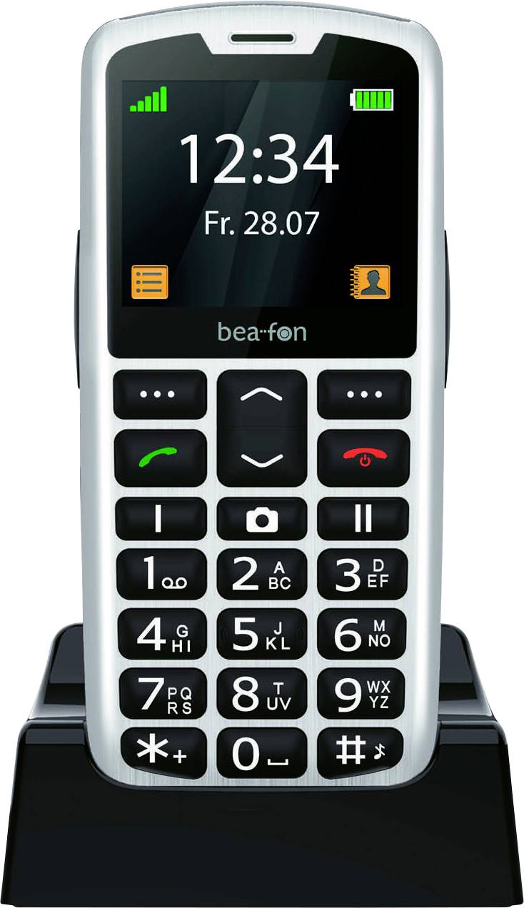 Ein schwarzes und weißes Mobiltelefon mit großen Tasten auf einer Ladestation. Das Display zeigt „12:34 Fr. 28.07