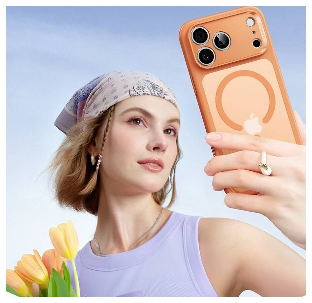 Eine Person mit einem Kopftuch hält ein Smartphone mit einem Kreismuster auf der Hülle und posiert für ein Selfie mit Tulpen im Vordergrund.