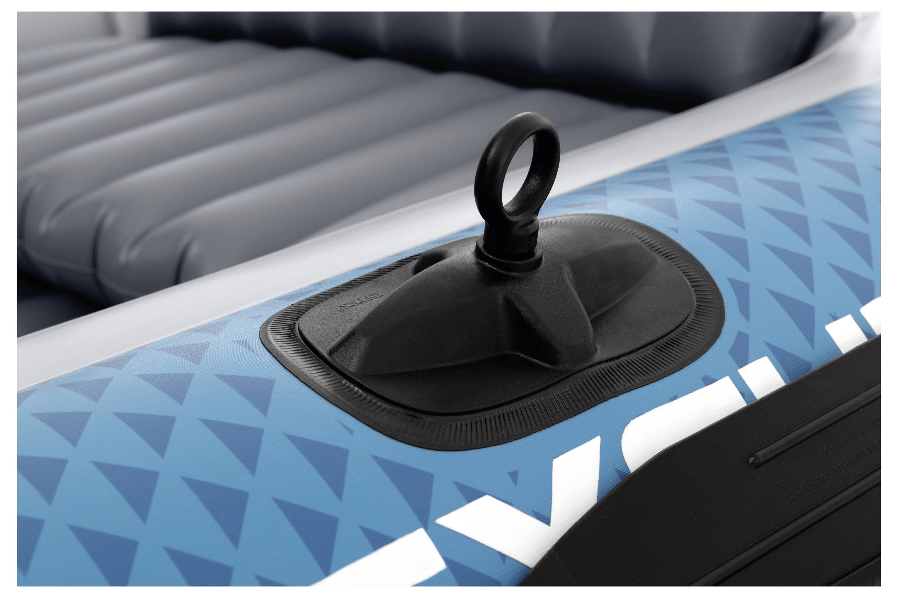 Nahaufnahme eines Luftventils eines blauen aufblasbaren Bootes mit einem runden Griff, umgeben von einem geometrischen Muster auf dem Material.