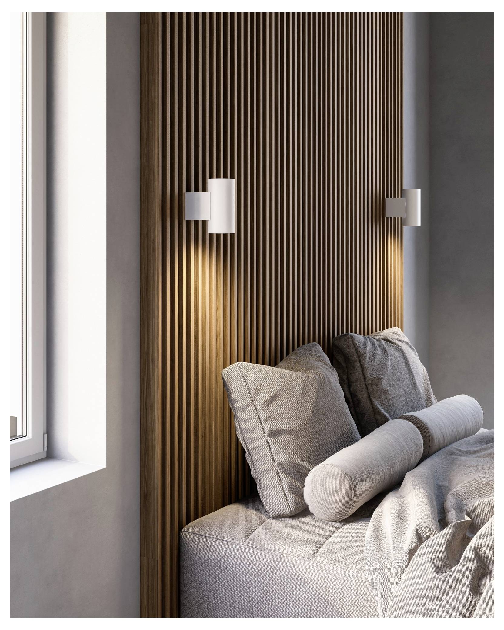 Modernes Schlafzimmer mit vertikal lamelliertem Holzkopfteil, weichem grauem Bettzug und zwei weißen Wandleuchten, die eine gemütliche Atmosphäre schaffen.