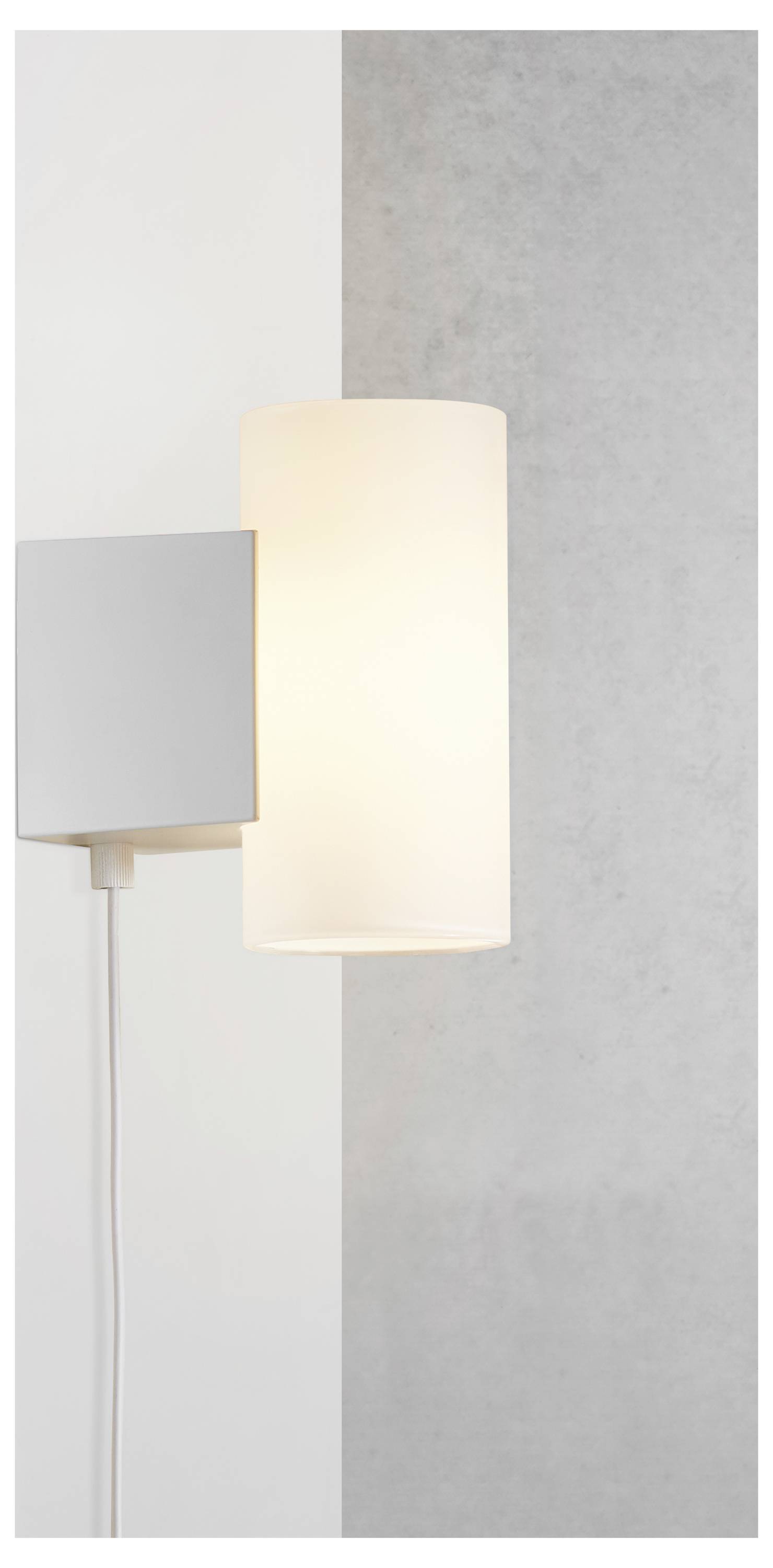 Eine moderne, an der Wand montierte Lampe mit zylindrischem Schirm, die weiches, warmes Licht gegen einen weiß- und graustrukturierten Hintergrund ausstrahlt.