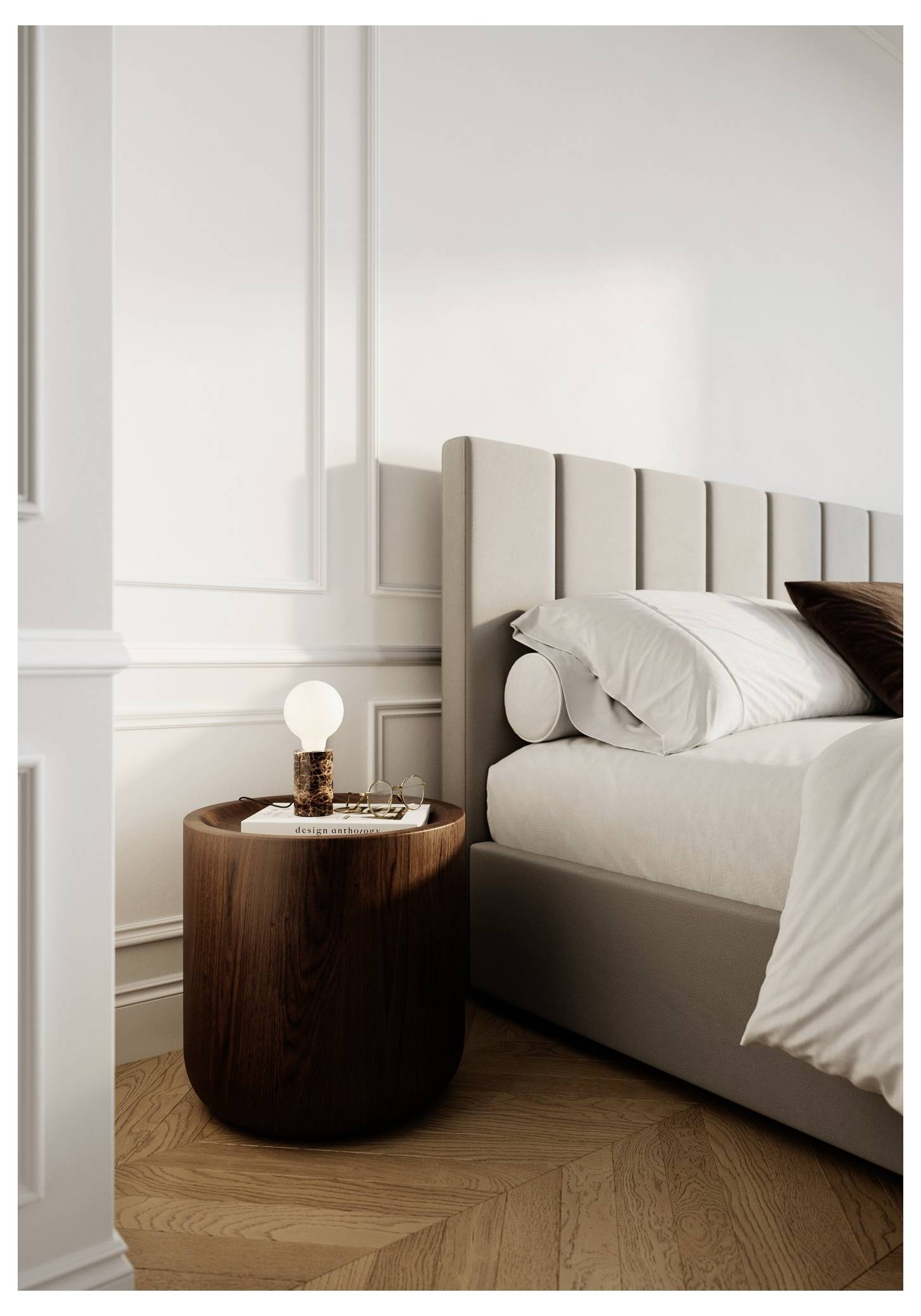 Ein gemütliches Schlafzimmer zeigt ein Bett mit neutraler Bettwäsche und einem gesteppten Kopfteil. Ein hölzerner Nachttisch trägt eine brennende Lampe und ein kleines Buch.