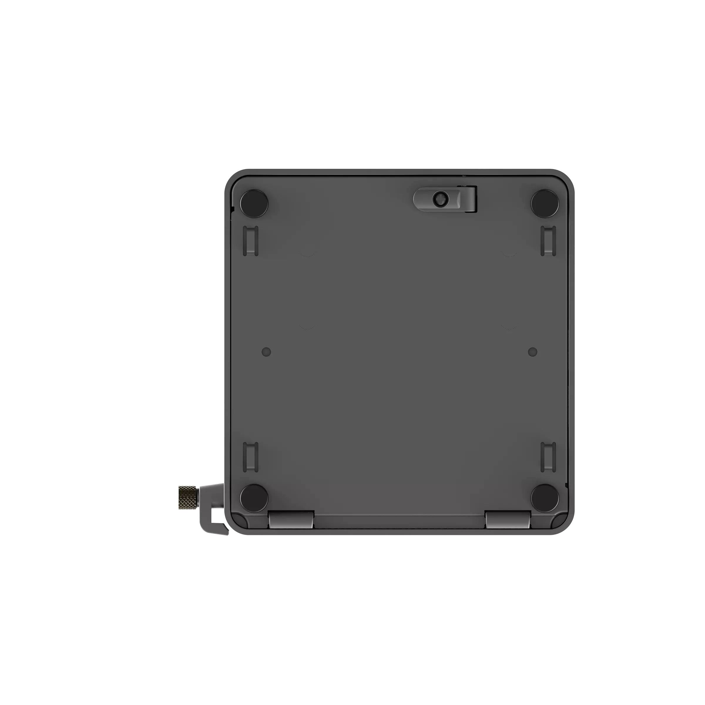 Rückansicht eines kleinen grauen quadratischen elektronischen Geräts mit abgerundeten Ecken, vier Gumminoppen und einer seitlichen Befestigungshalterung.