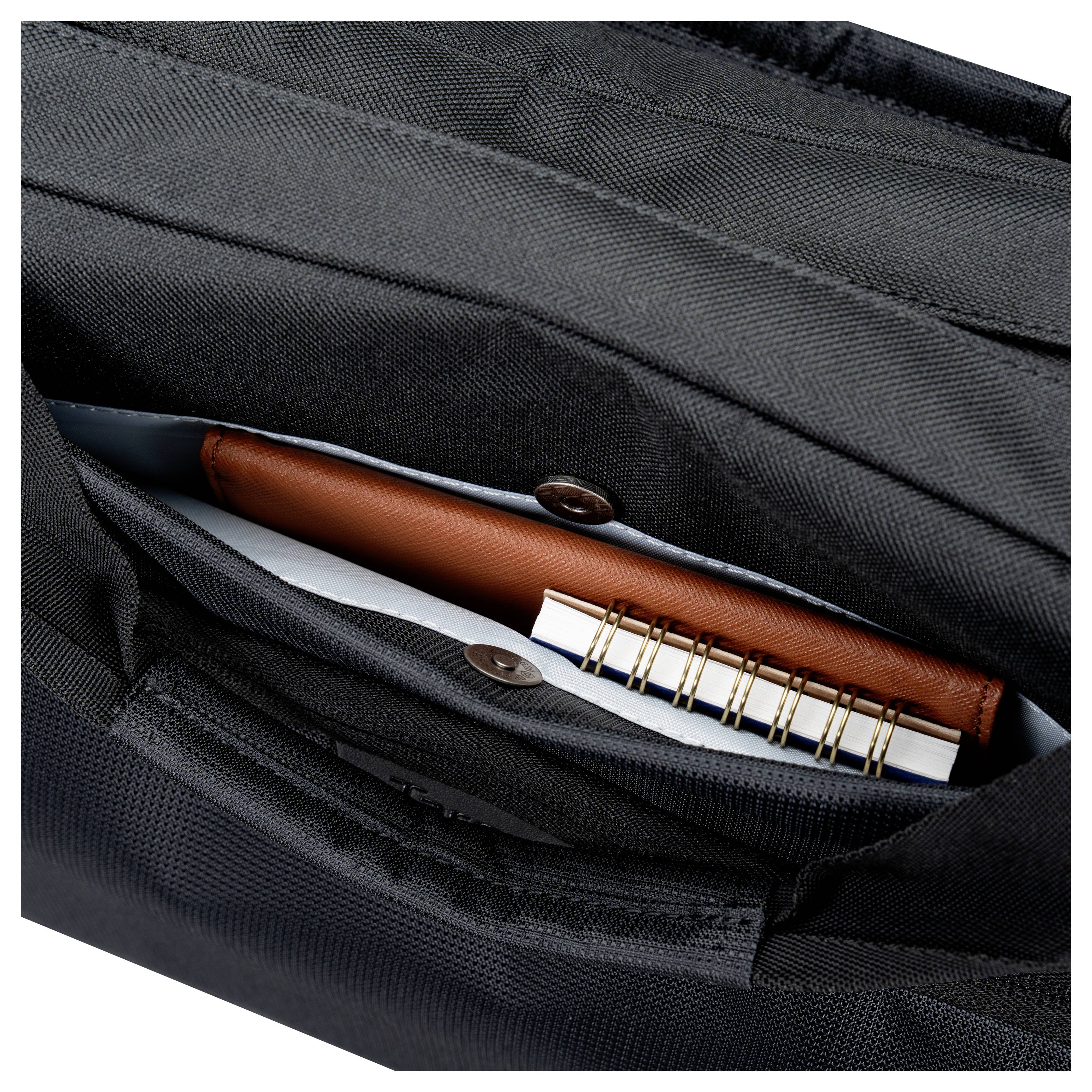 Offene schwarze Rucksacktasche mit einem braunen Notizbuch, weißen Papieren und einem Stift.