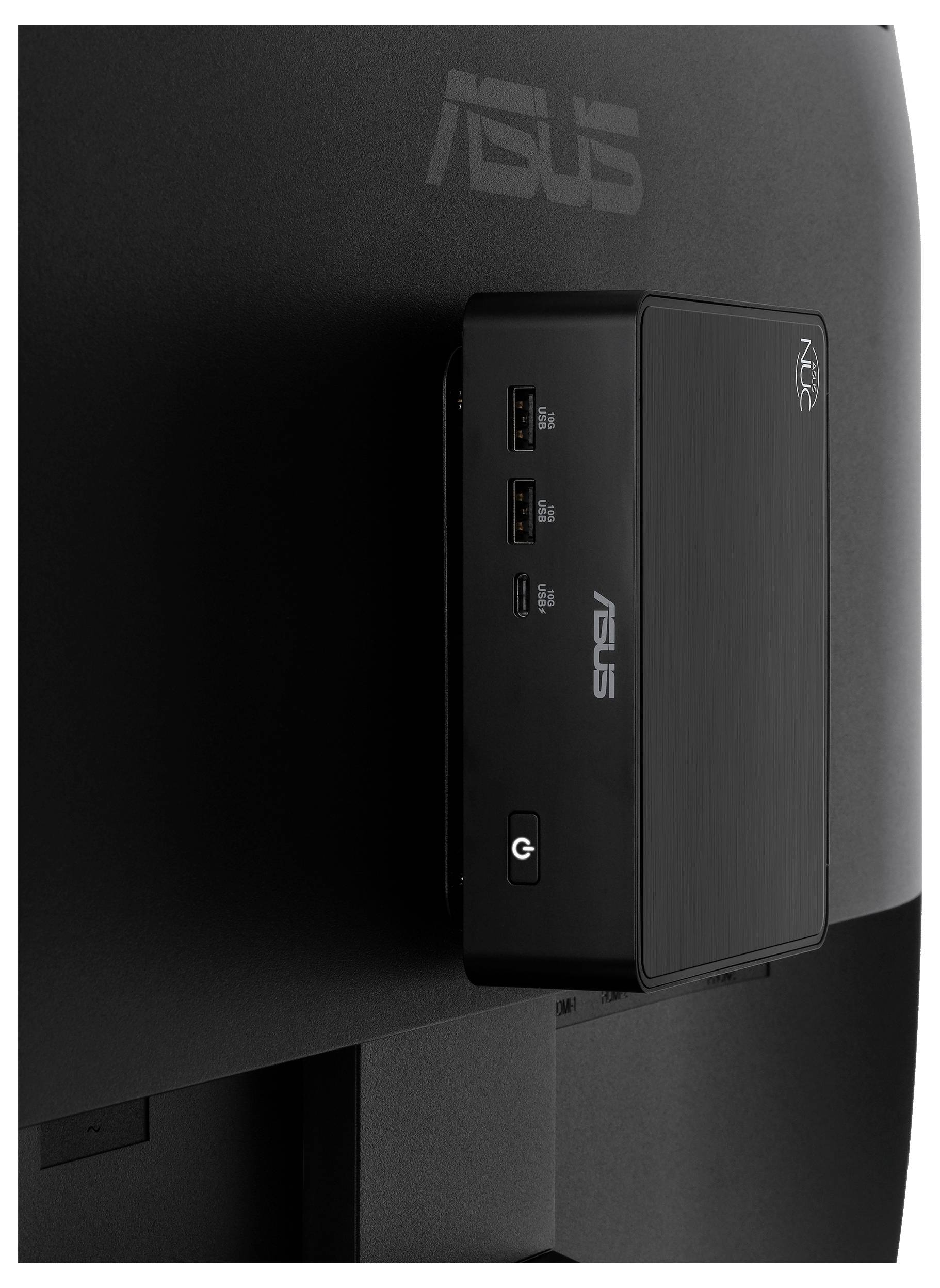 Nahaufnahme eines ASUS-Mini-PCs, der auf der Rückseite eines Monitors montiert ist, zeigt vordere USB-Anschlüsse und Einschaltknopf.