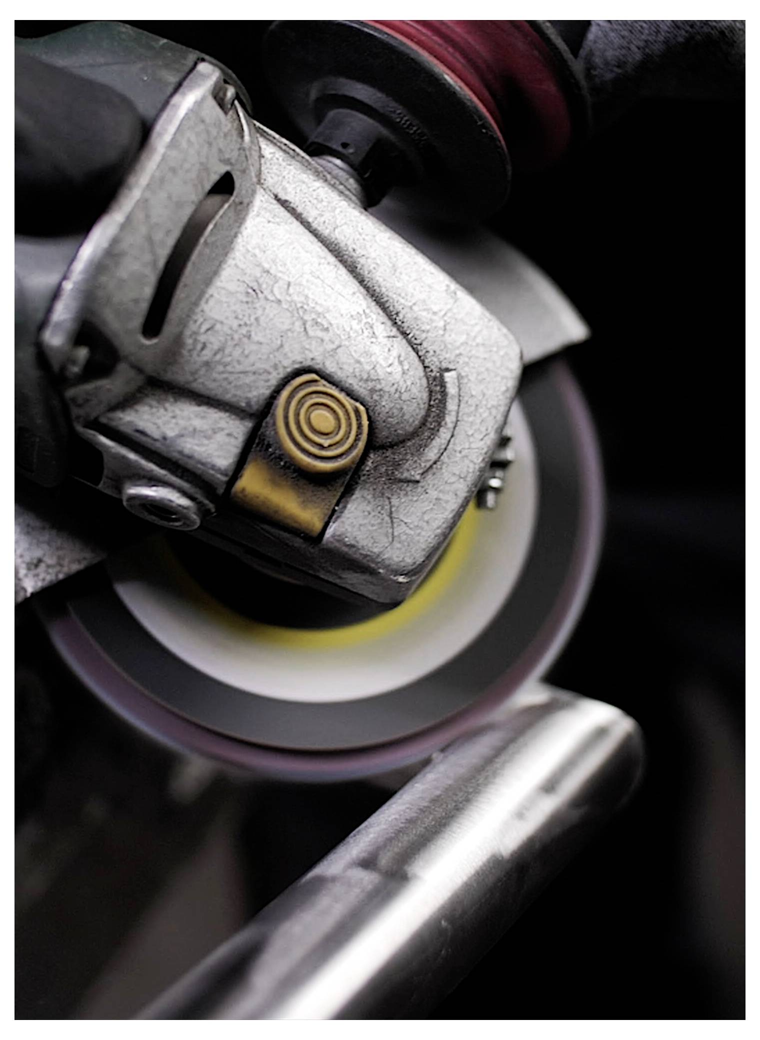 Ein Nahaufnahmedetail eines Elektroschleifers in Gebrauch, wobei Funken fliegen, während er durch Metall schneidet, und zeigt Bewegung und Fokus auf die Schneidscheibe.