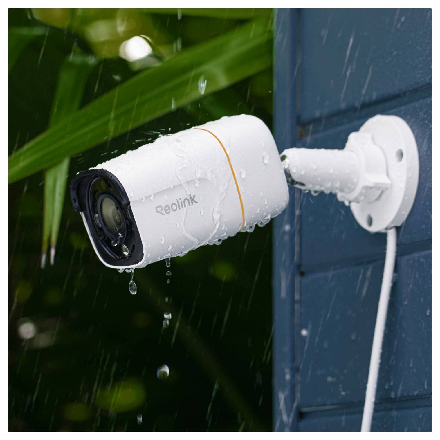 Eine Sicherheitskamera, die an einer Außenmauer im Regen montiert ist und trotz nasser Bedingungen Außenaufnahmen aufzeichnet.