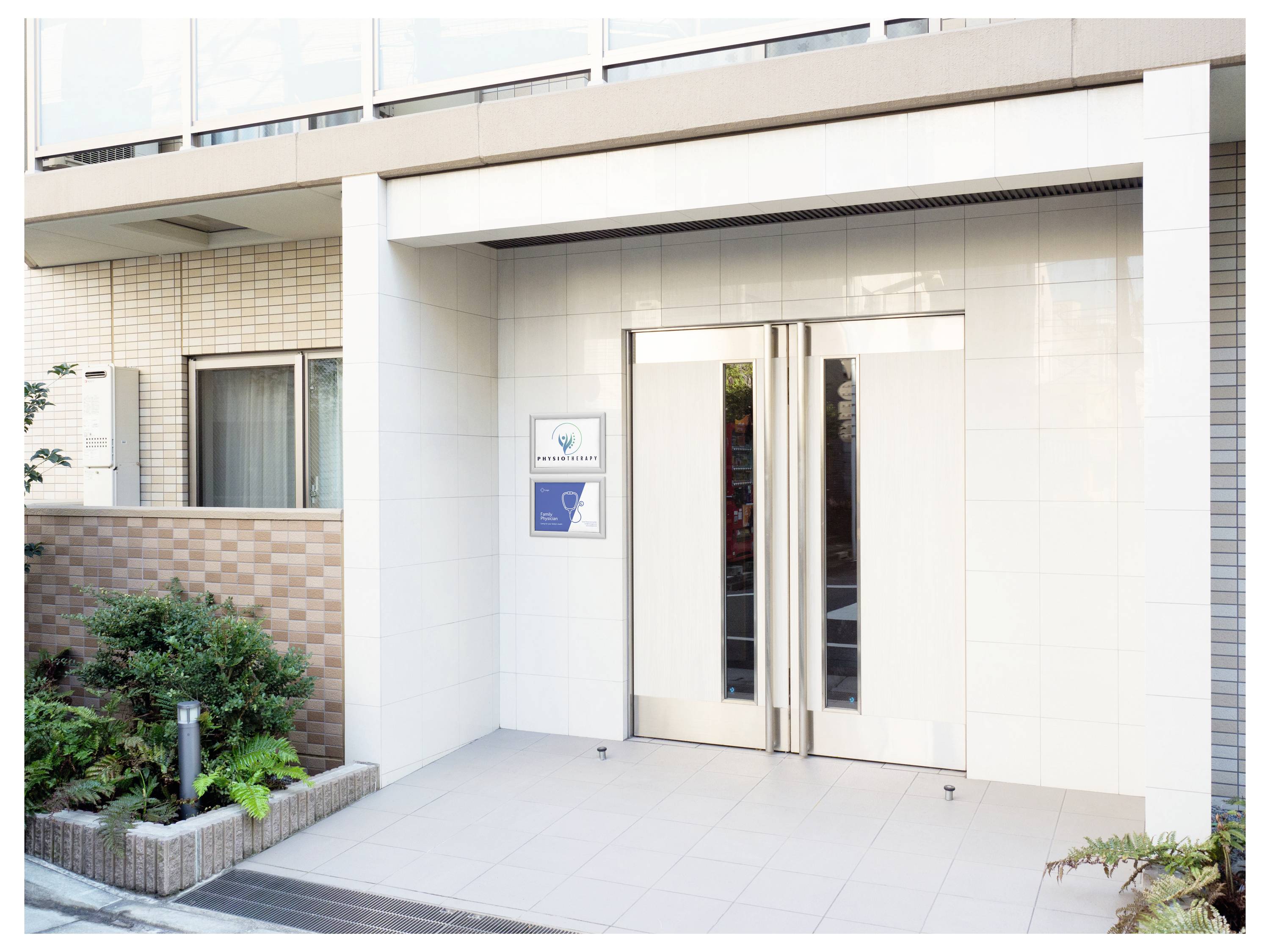 Eingang zu einem modernen Gebäude mit großen Doppeltüren und einem kleinen Gartenbereich auf der linken Seite.