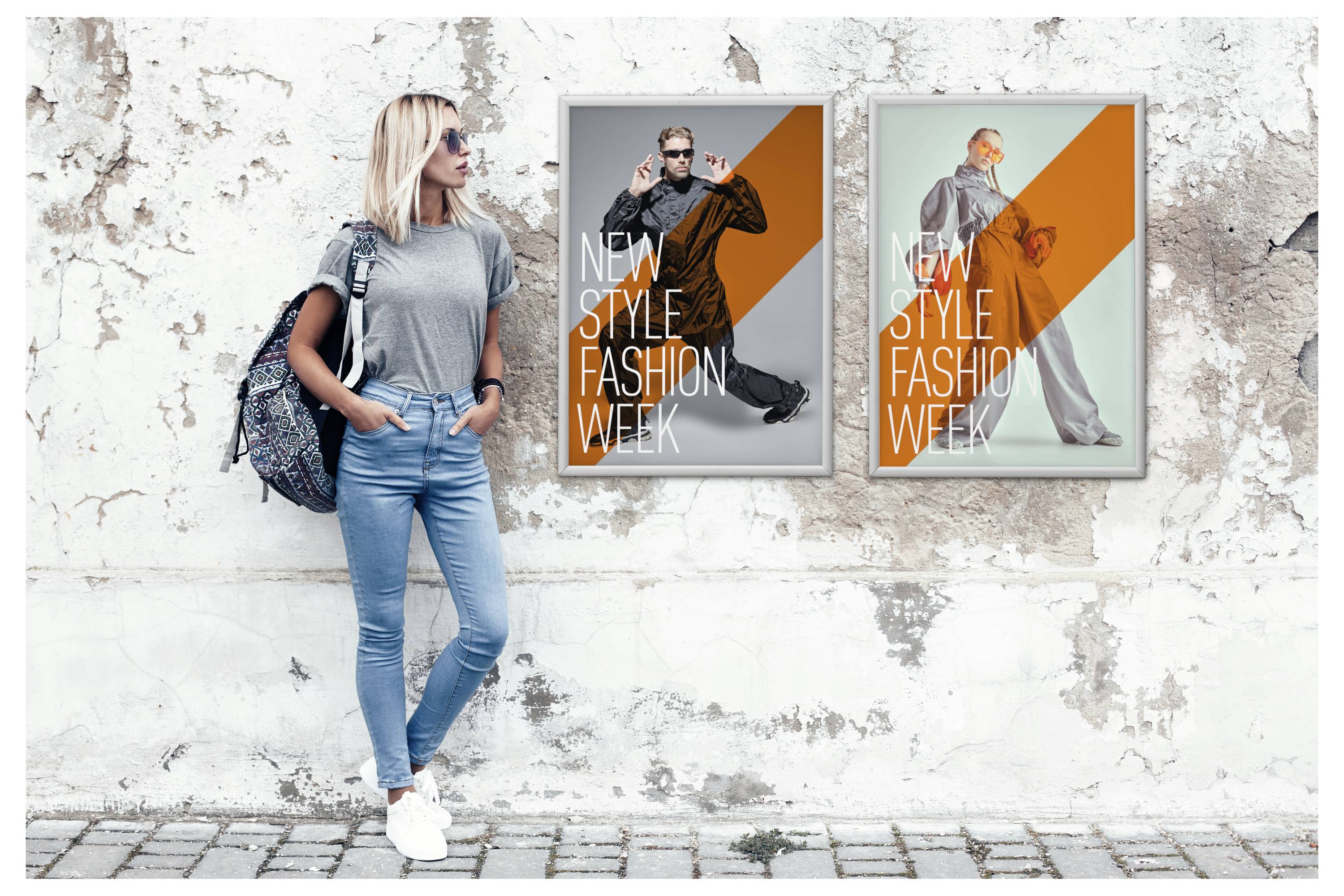 Eine Frau in legerer Kleidung steht an einer verwitterten Wand, neben zwei Plakaten, die die „New Style Fashion Week