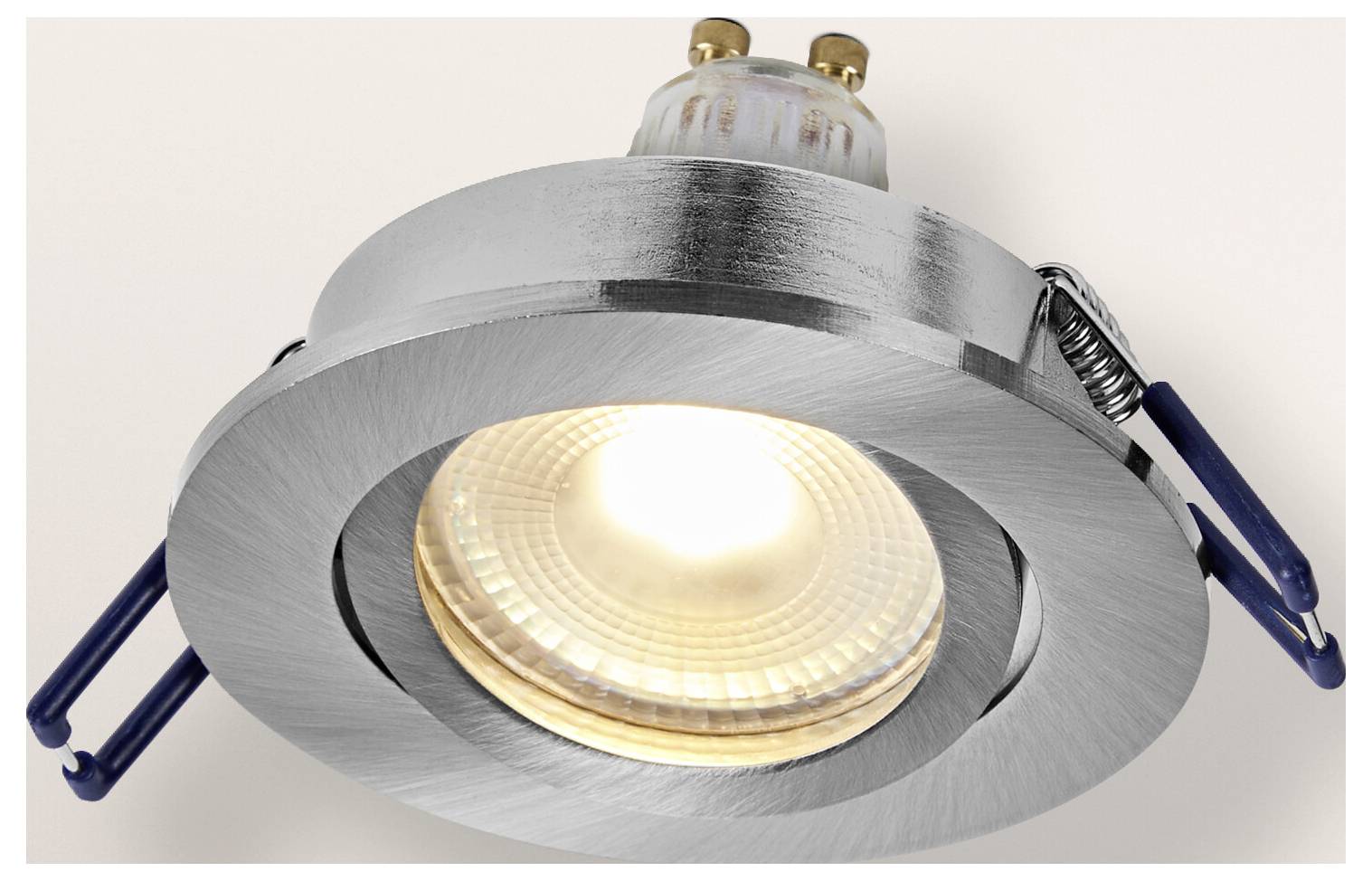 Ein runder, kupferfarbener LED-Einbaustrahler mit verstellbaren Winkeln, an einer weißen Decke montiert.