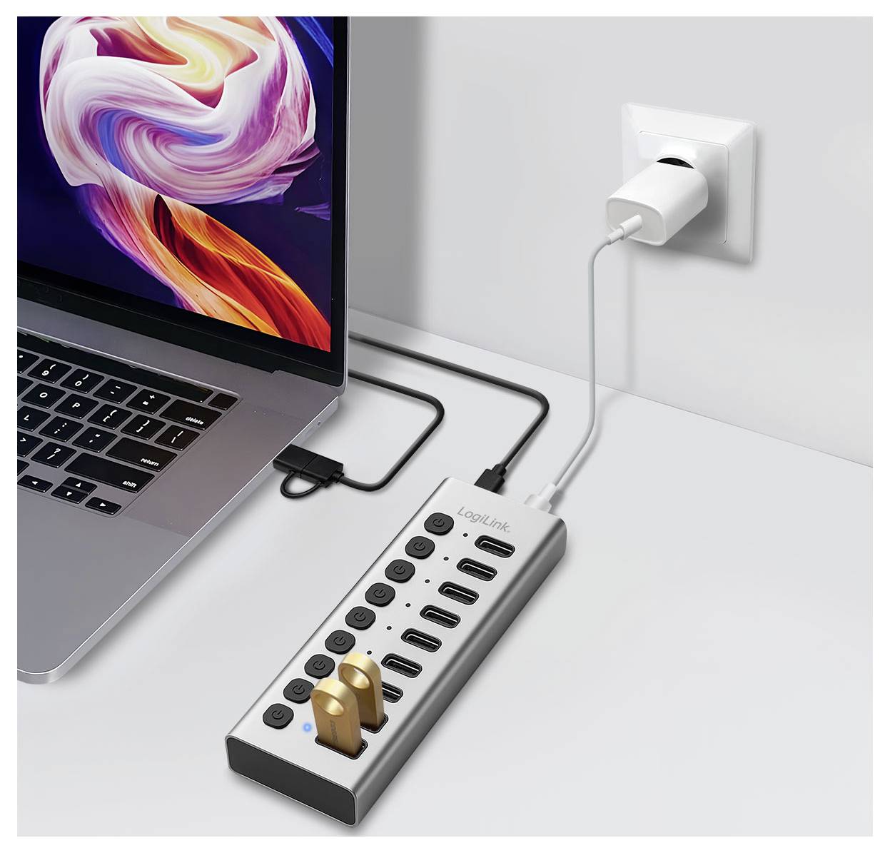 Laptop, der an einen Multiport-Ladehub angeschlossen ist, der in eine Wandsteckdose eingesteckt ist, mit mehreren USB-Geräten und Stromsteckern angeschlossen.