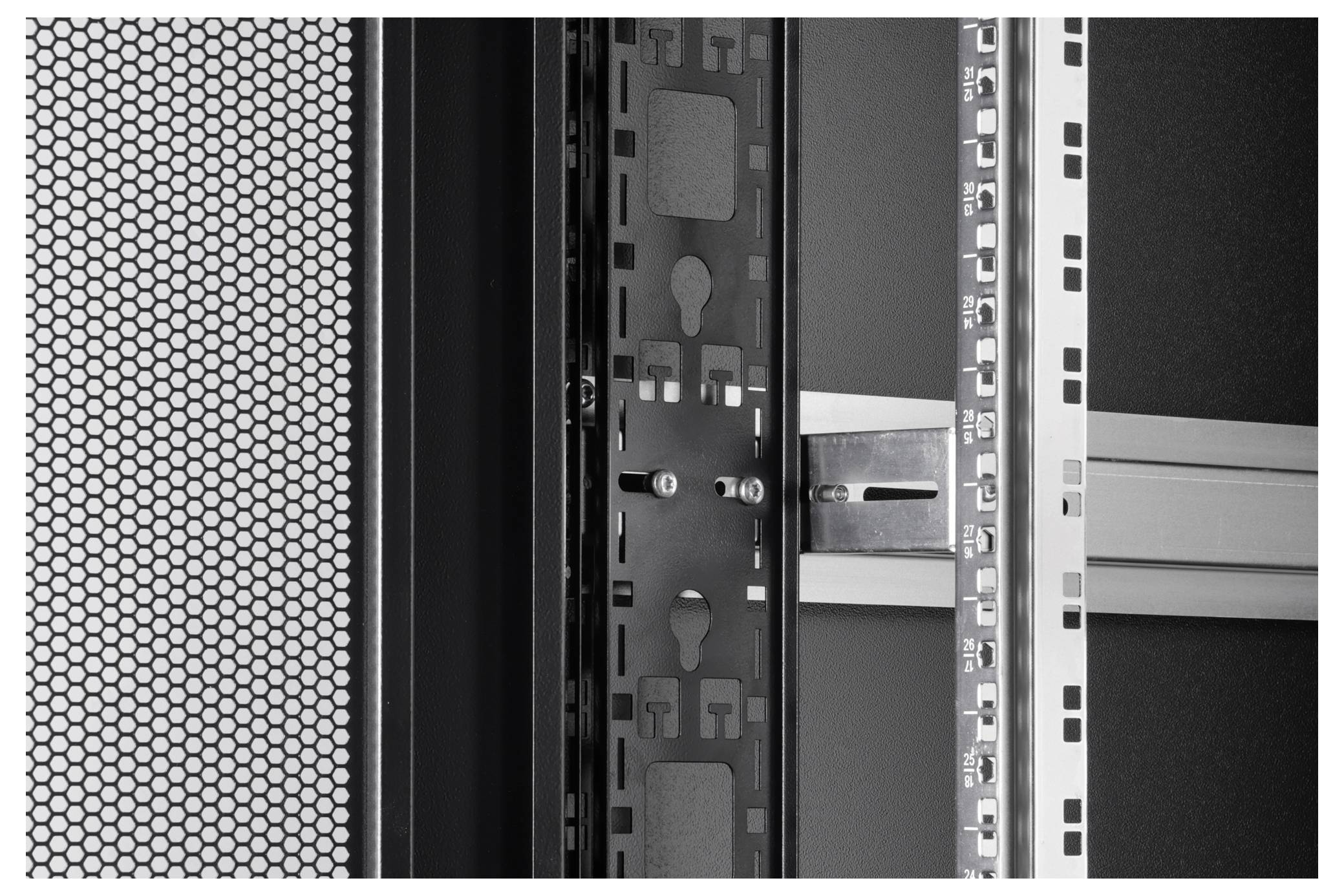 Nahaufnahme eines Serverracks mit perforierter Tür auf der linken Seite, die leere Regale und metallisches Gestell in einem Rechenzentrum zeigt.