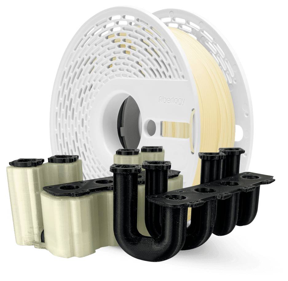 3D-gedruckte Kunststoff-Kabelclips und -halter in Schwarz, Beige und Weiß, mit einer großen Filamentspule im Hintergrund.