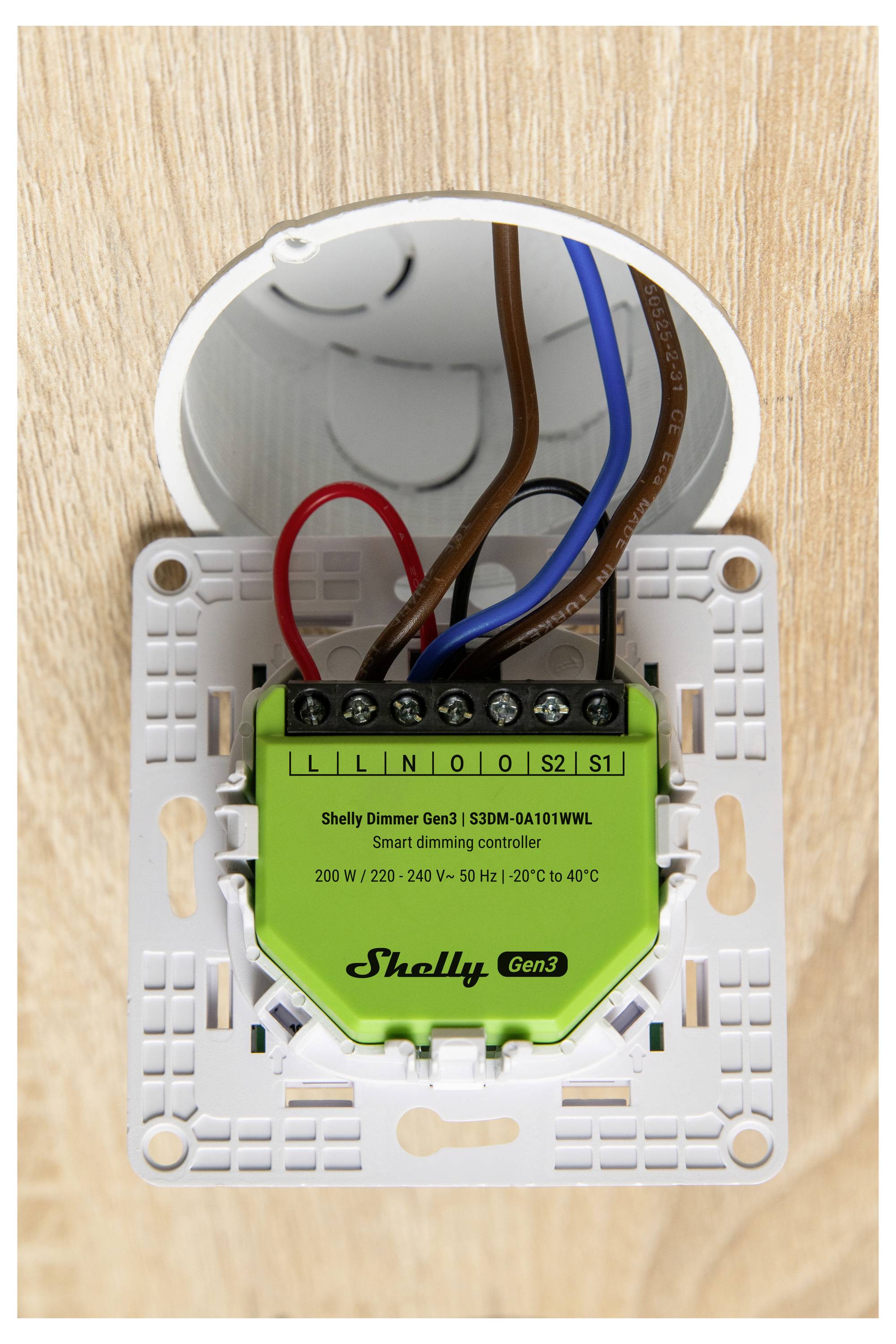 Ein intelligenter Dimmregler, der in einer runden Elektrobox installiert ist. Er trägt die Bezeichnung „Shelly Dimmer Gen3