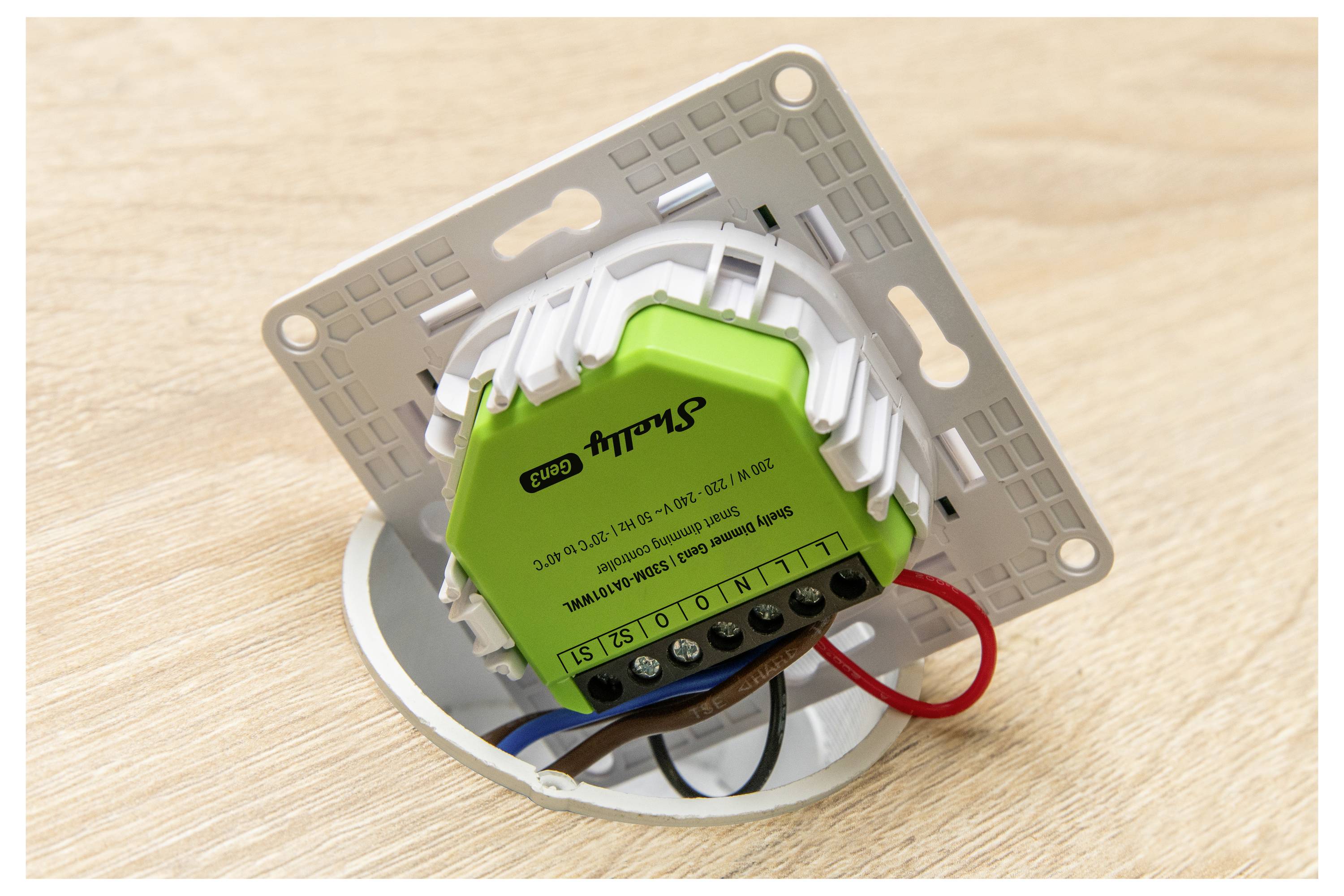 Eine Nahaufnahme eines angebrachten grünen elektrischen Geräts mit Verkabelung, beschriftet mit „Shelly 2.5