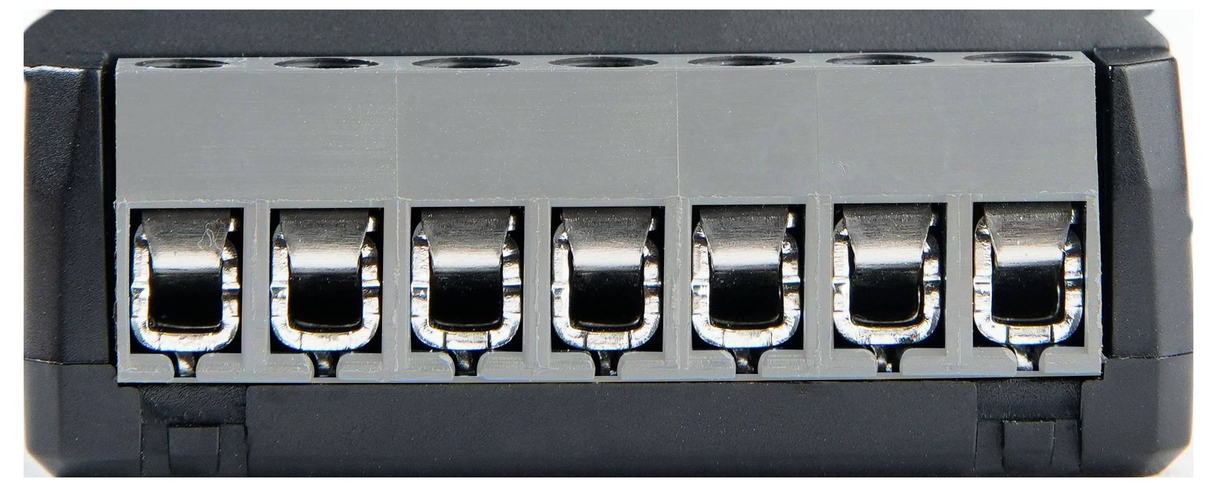 Elektrische Anschlussklemme mit sieben Anschlüssen zum sicheren Anschluss von Drähten, ausgelegt für Verteil- und Erdungszwecke.