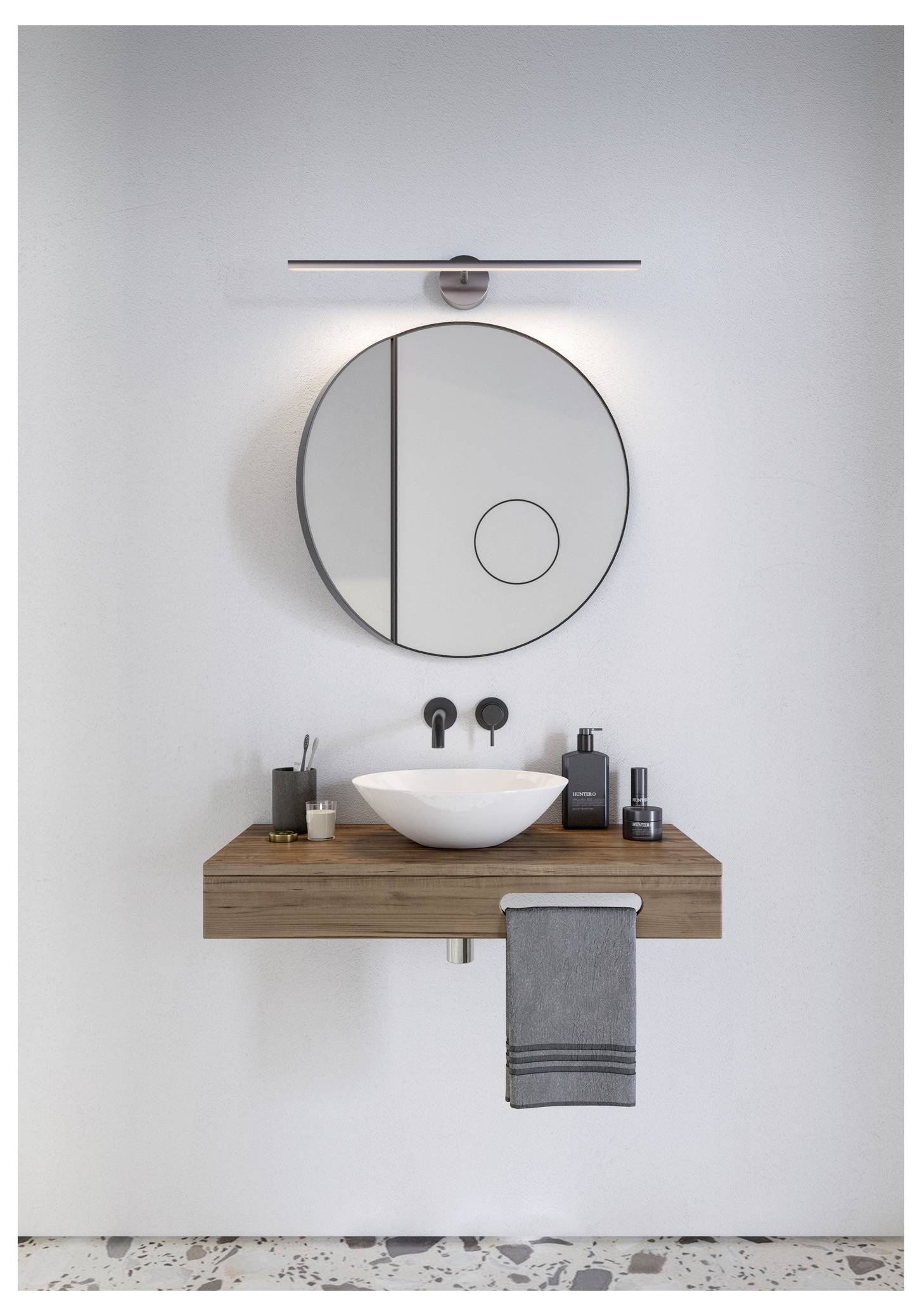 Ein modernes Badezimmer mit einem hölzernen schwebendem Waschtisch, einem weißen Aufsatzwaschbecken, einem runden Spiegel darüber und minimalistischer Beleuchtung.