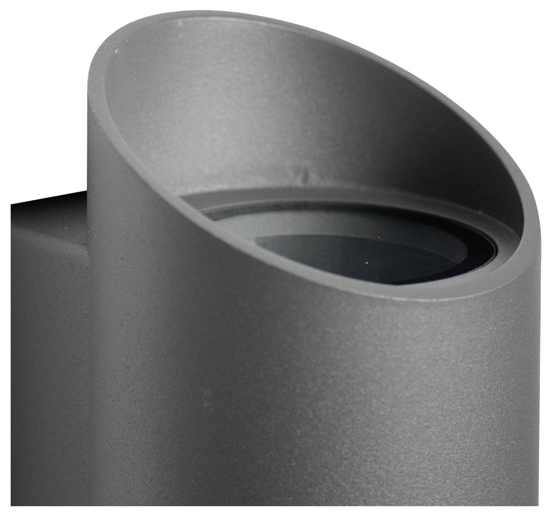 Nahaufnahme eines zylindrischen, dunkelgrauen Objekts mit einer abgewinkelten Öffnung, das einer minimalistischen modernen Leuchte ähnelt und sein schlankes Design zur Schau stellt.
