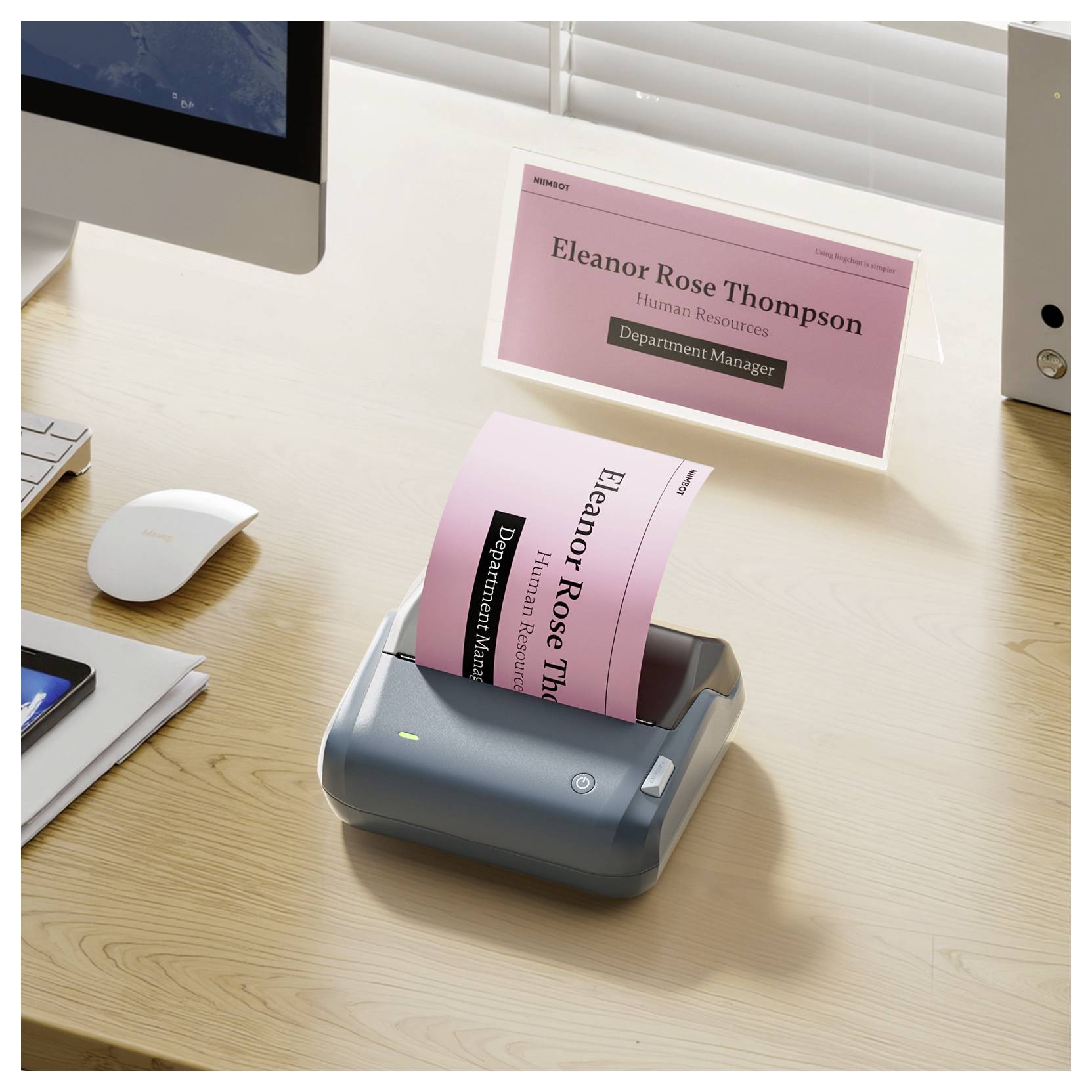 Visitenkarte wird auf einem Desktop-Drucker gedruckt; Karte zeigt „Eleanor Rose Thompson