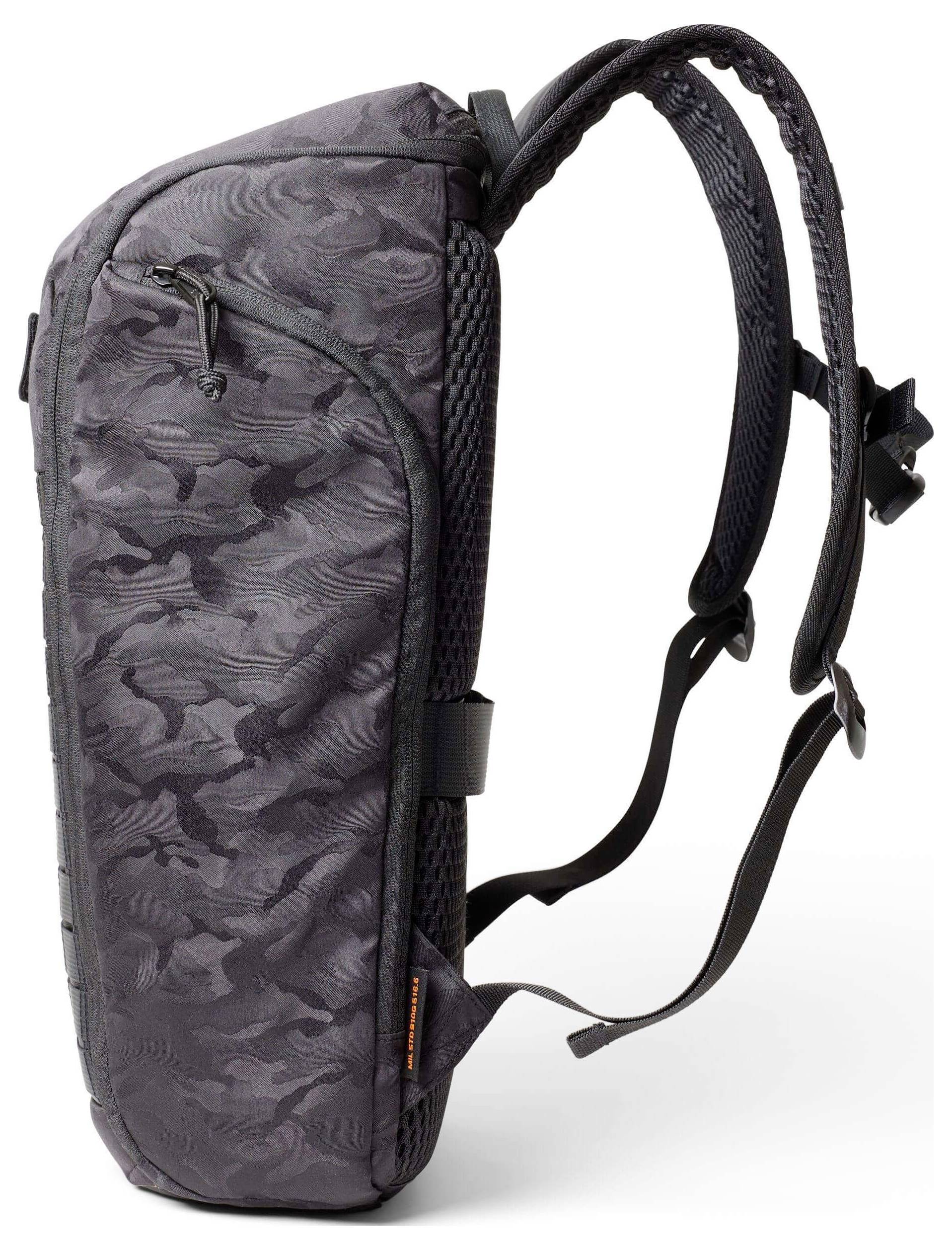 Ein Rucksack mit schwarz-grauem Camouflage-Muster, ausgestattete mit verstellbaren gepolsterten Schultergurten, seitlicher Tasche und oberem Reißverschluss für Lagerzugriff.