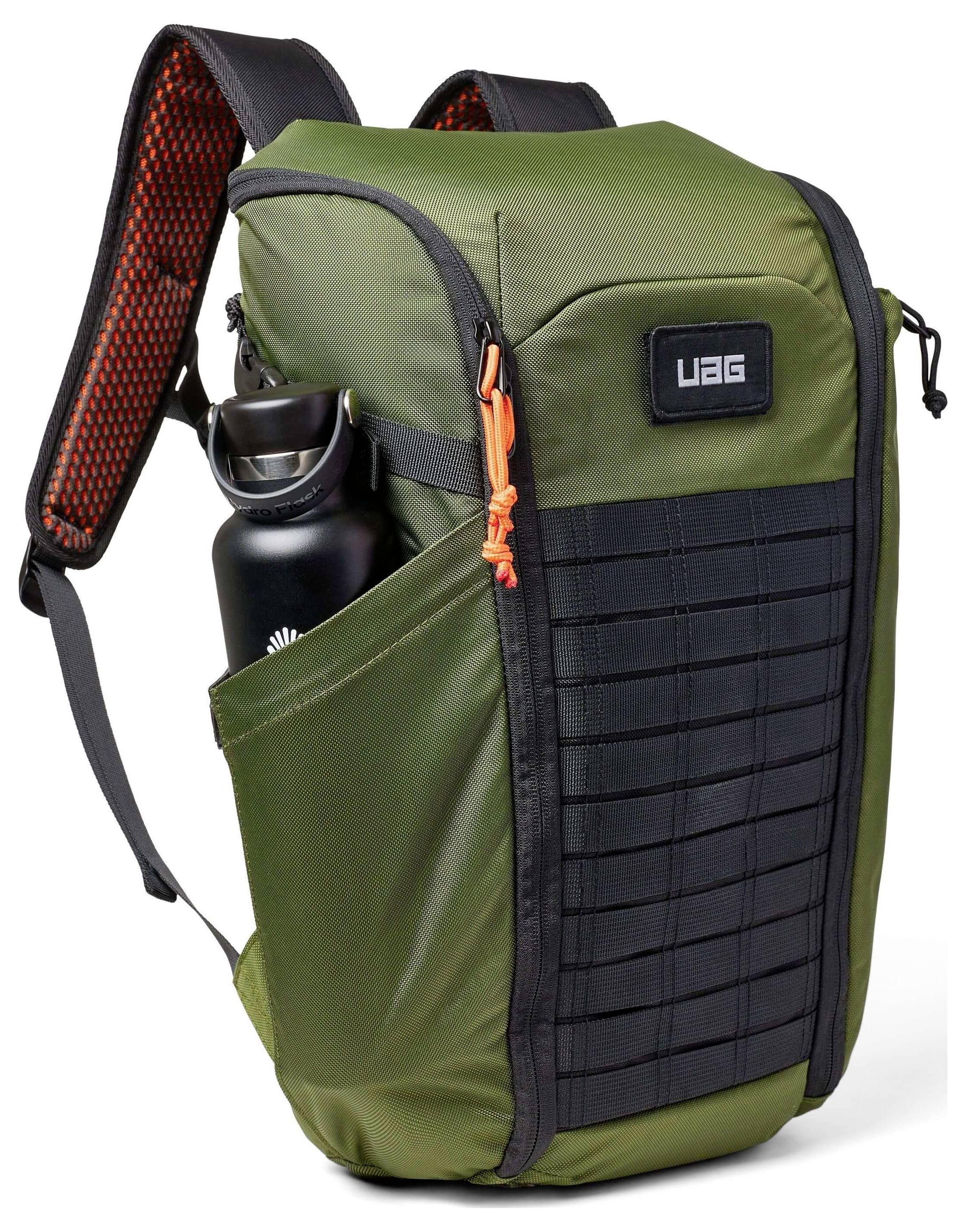 Ein grün und schwarz karierter Rucksack mit UAG-Logo, mit einem orangefarbenen Reißverschluss, einer Netzentasche und einer Wasserflasche an der Seite.