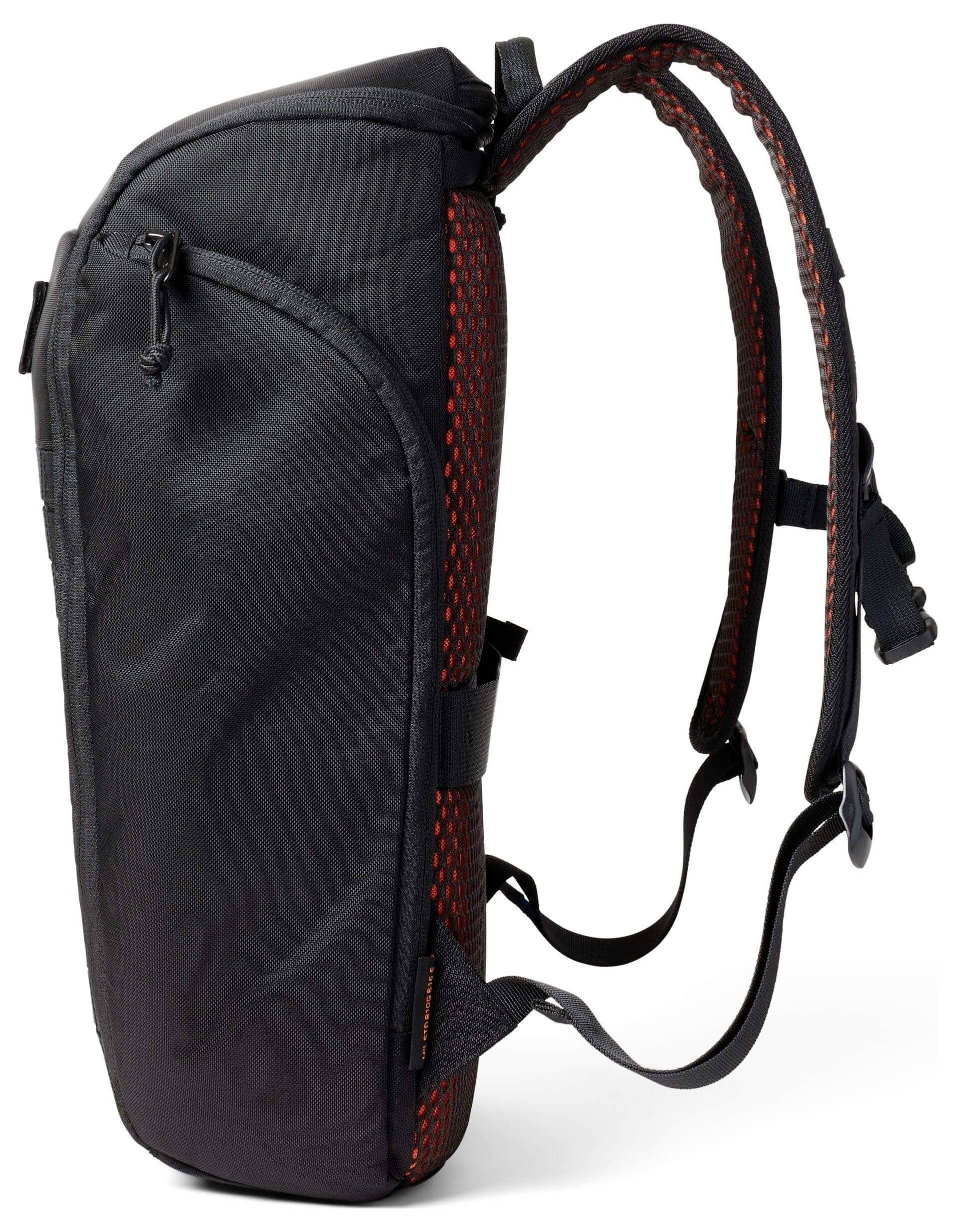 Ein Seitenprofil eines schwarzen Rucksacks mit roten Akzenten und verstellbaren Riemen. Der Rucksack hat ein schlankes Design und eine Vordertasche mit Reißverschluss.