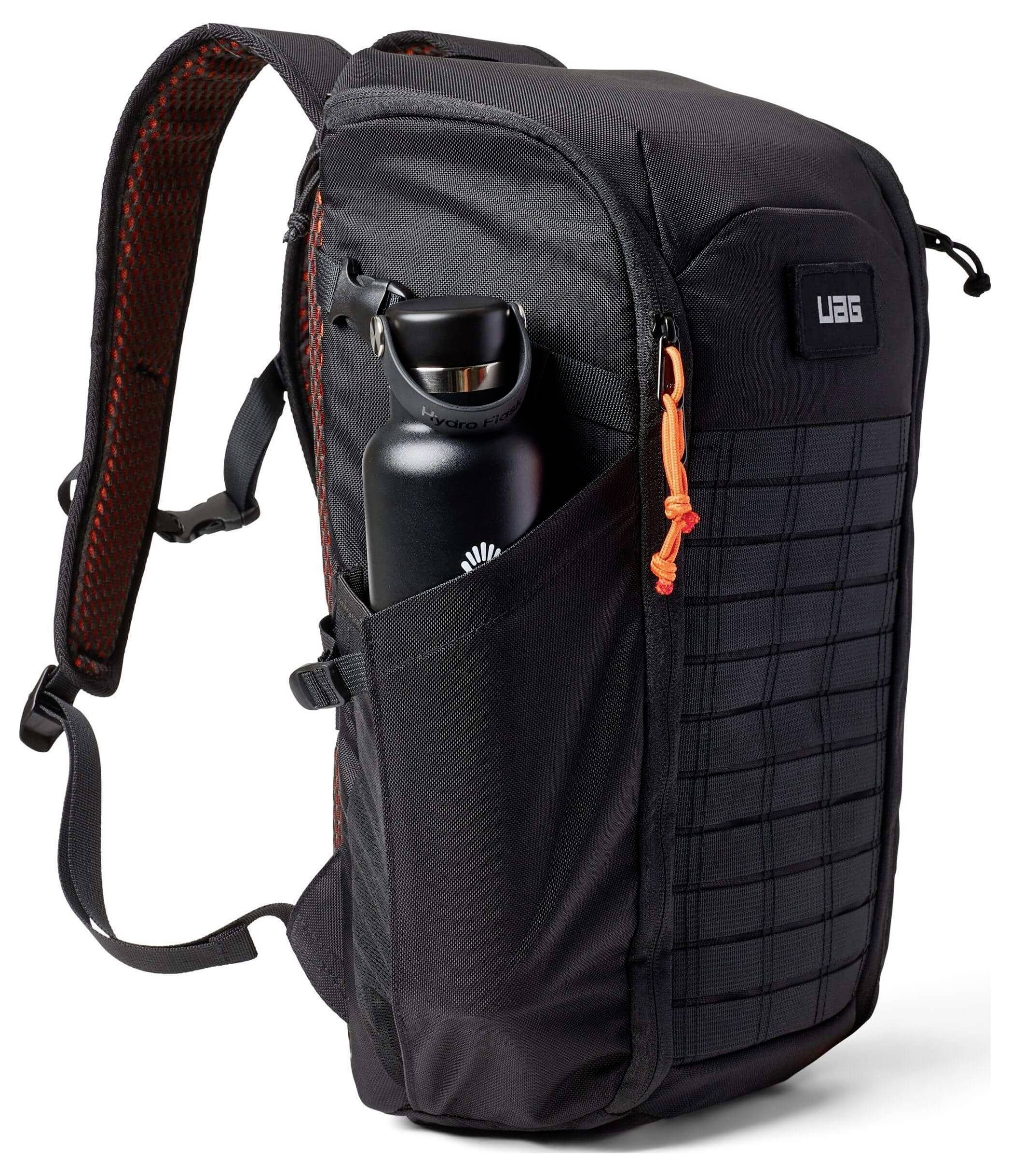 Ein schwarzer Rucksack mit rotem Innenfutter und einer Seitentasche, die eine schwarze Wasserflasche hält. Er hat gepolsterte Riemen, ein Gittermuster auf der Vorderseite und einen orangefarbenen Reißverschlusszipper.