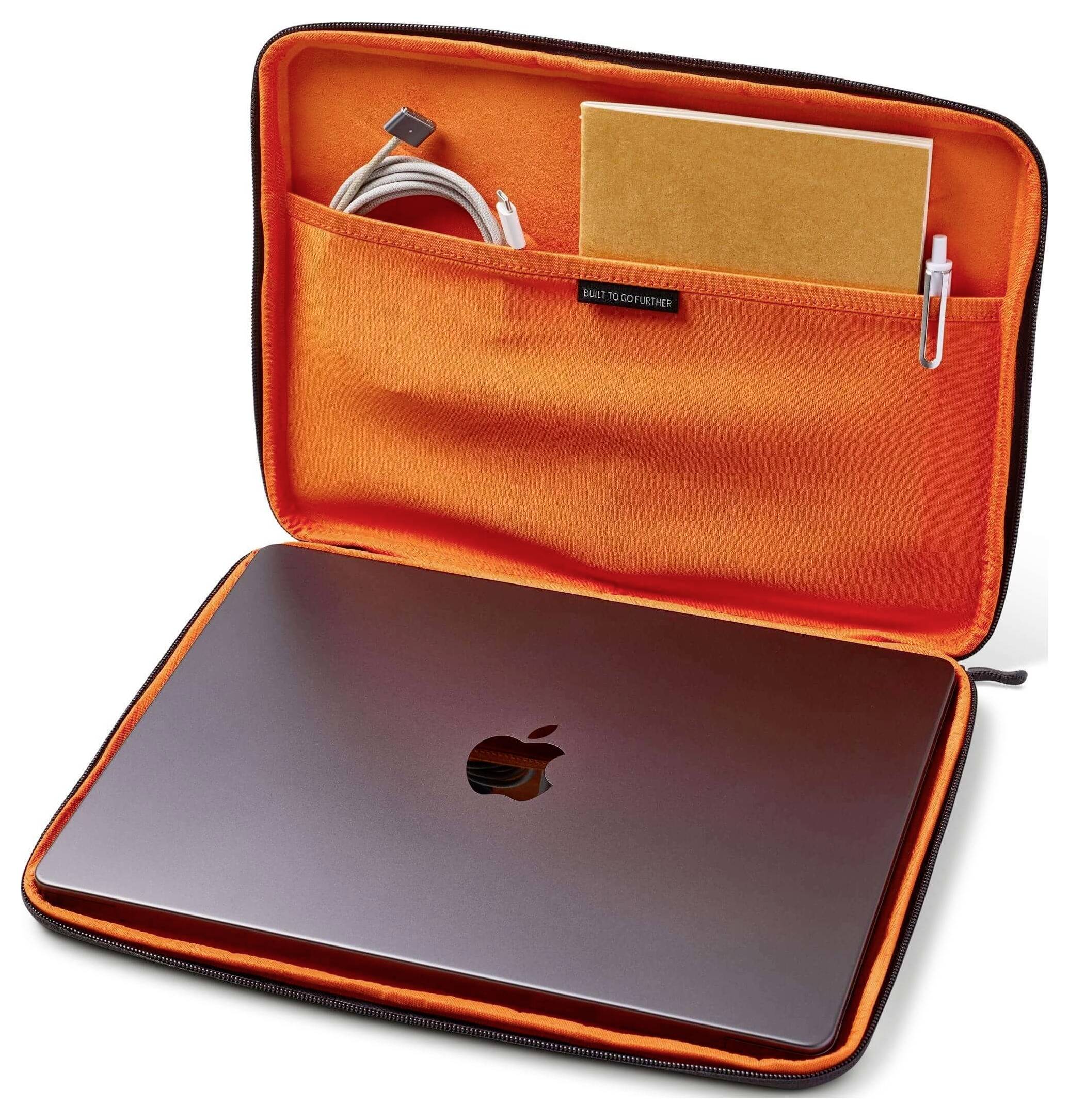 Ein Laptop in einer offenen orange Schutztasche mit zwei Taschen. Eine Tasche enthält ein Notizbuch und einen Stift, die andere ein Ladekabel.